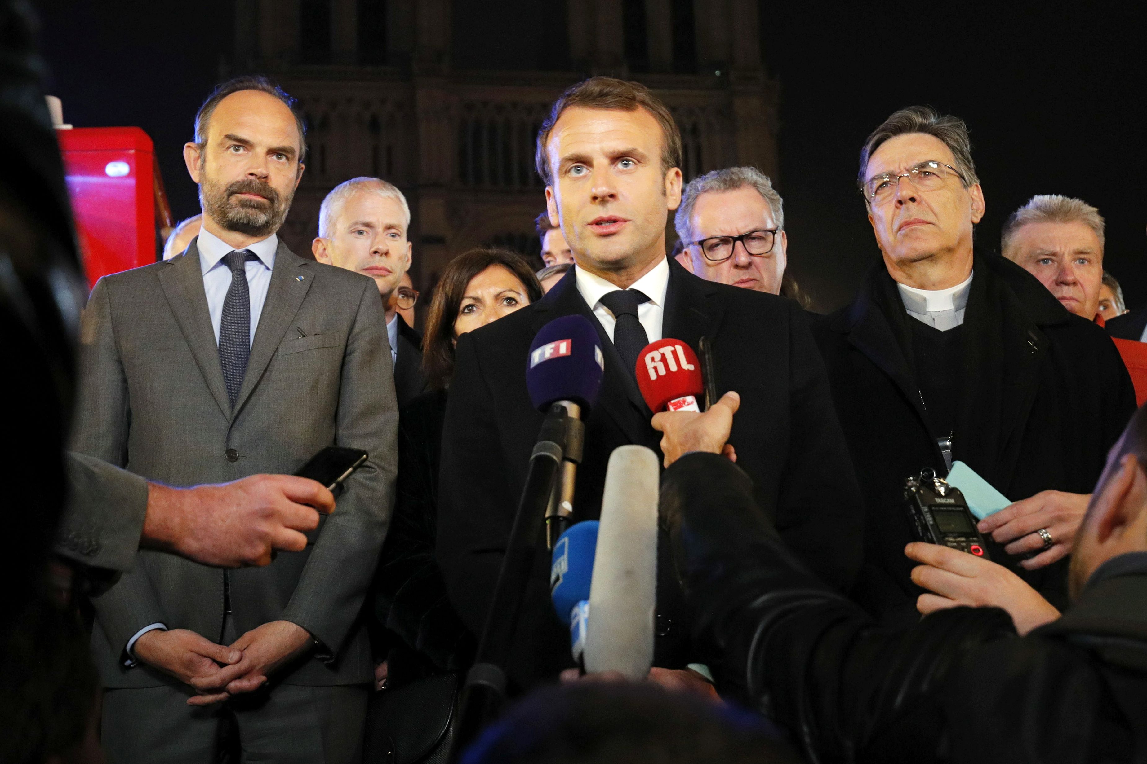 Presiden Prancis Emanuelle Macron berbicara kepada media di depan Katedral Notre Dame yang terbakar.