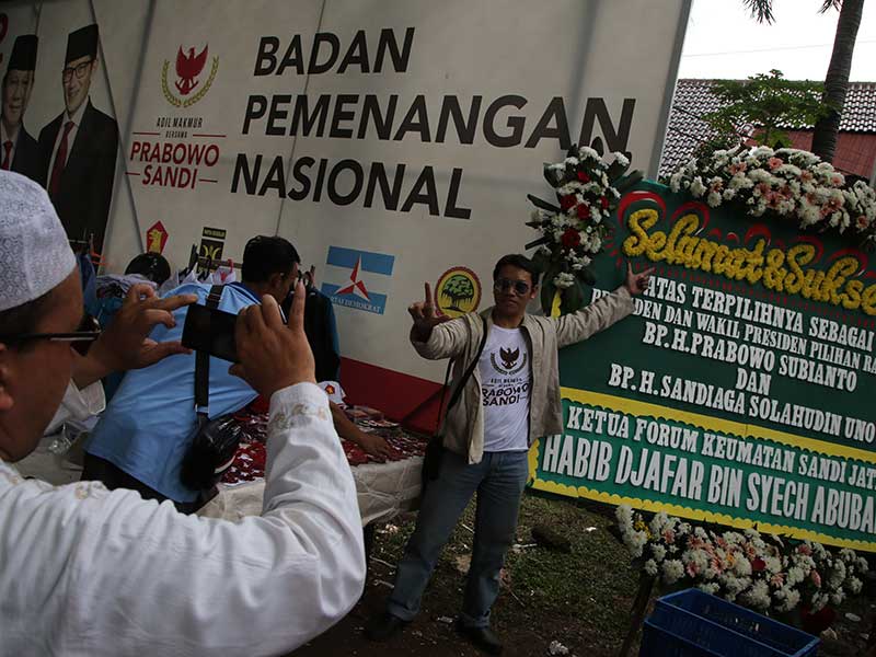 Pendukung Calon Presiden nomor urut 02 Prabowo Subianto foto didekat karangan bunga ucapan selamat saat menghadiri acara Syukur Kemenangan 
