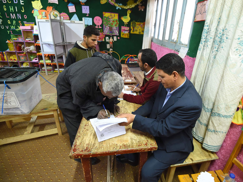 Warga Mesir memberikan menandatangani setelah memilih