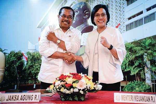 MENANGI GUGATAN: Jaksa Agung HM Prasetyo dan Menkeu Sri Mulyani Indrawati berjabat tangan seusai konferensi pers di Kejaksaan Agung, Jakarta