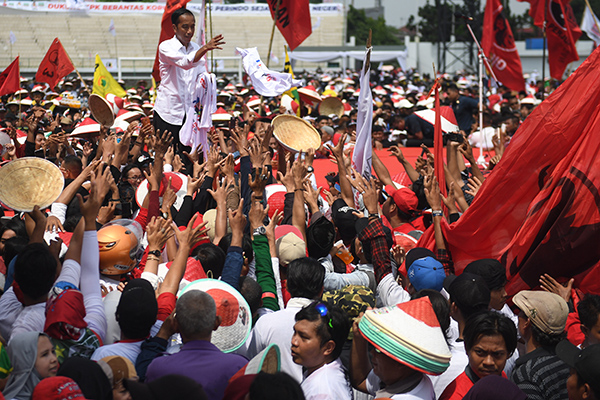  Calon Presiden nomor urut 01 Joko Widodo membagikan baju ke pendukungnya saat kampanye di Karawang