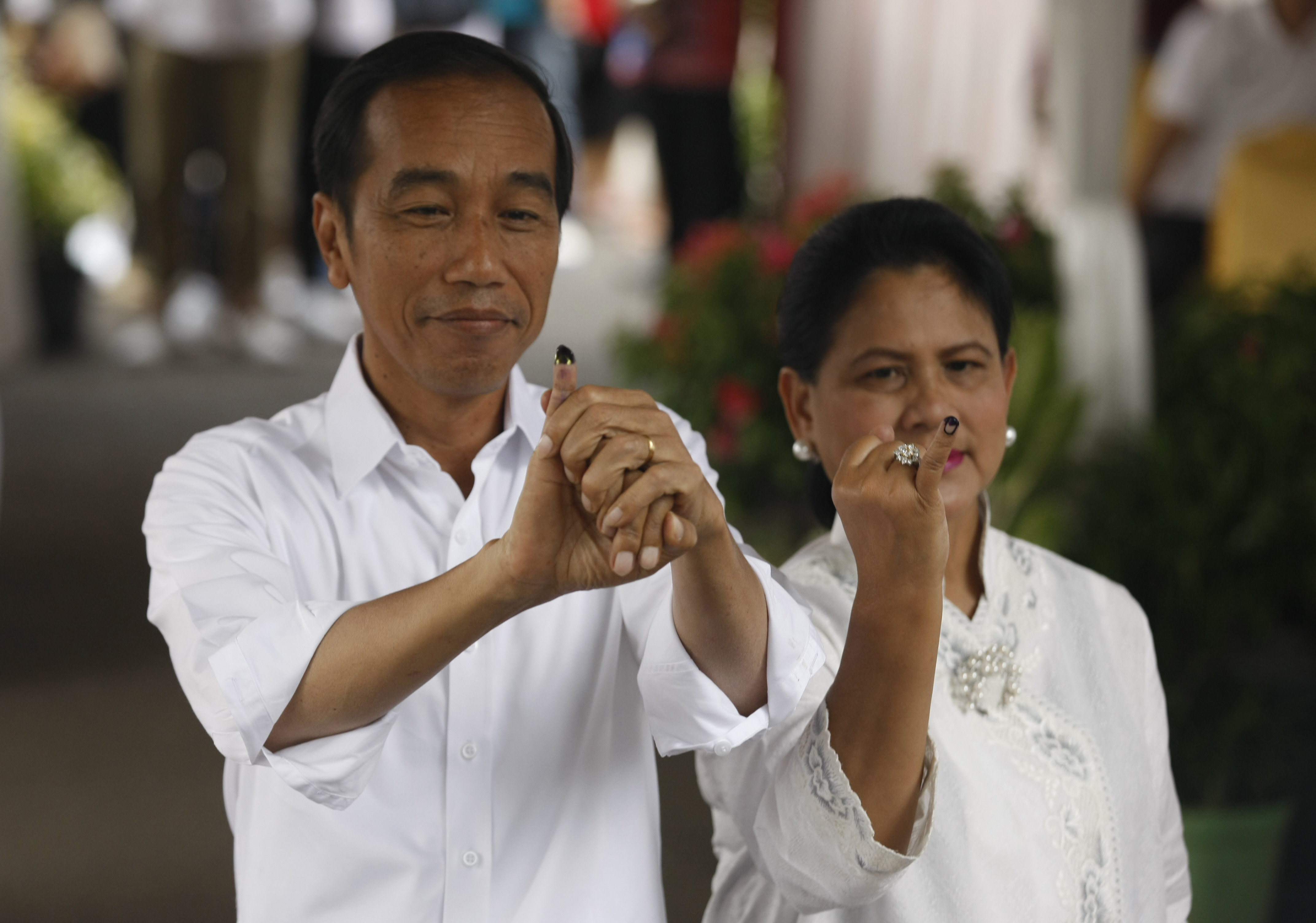 Capres nomor urut 01 Joko Widodo bersama istri Iriana usai menggunakan hak suara mereka.