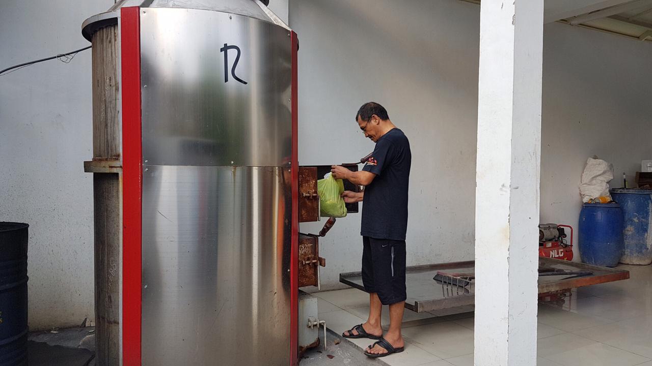 Warga sedang memasukkan sampah ke mesin insinerator di Perumahan Tytuan Kencana, Bekasi Utara