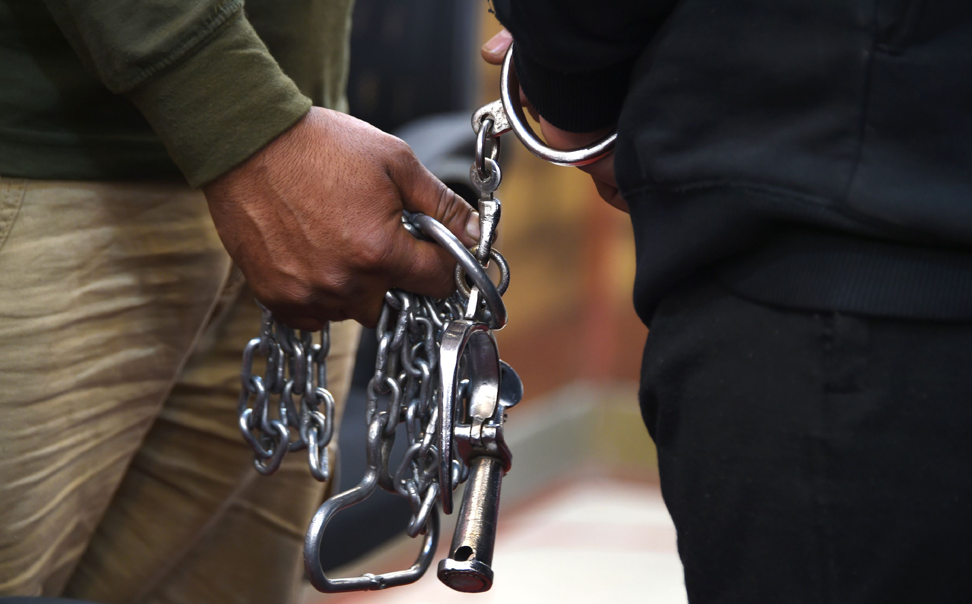 Seorang polisi Pakistan memegang borgol tangan