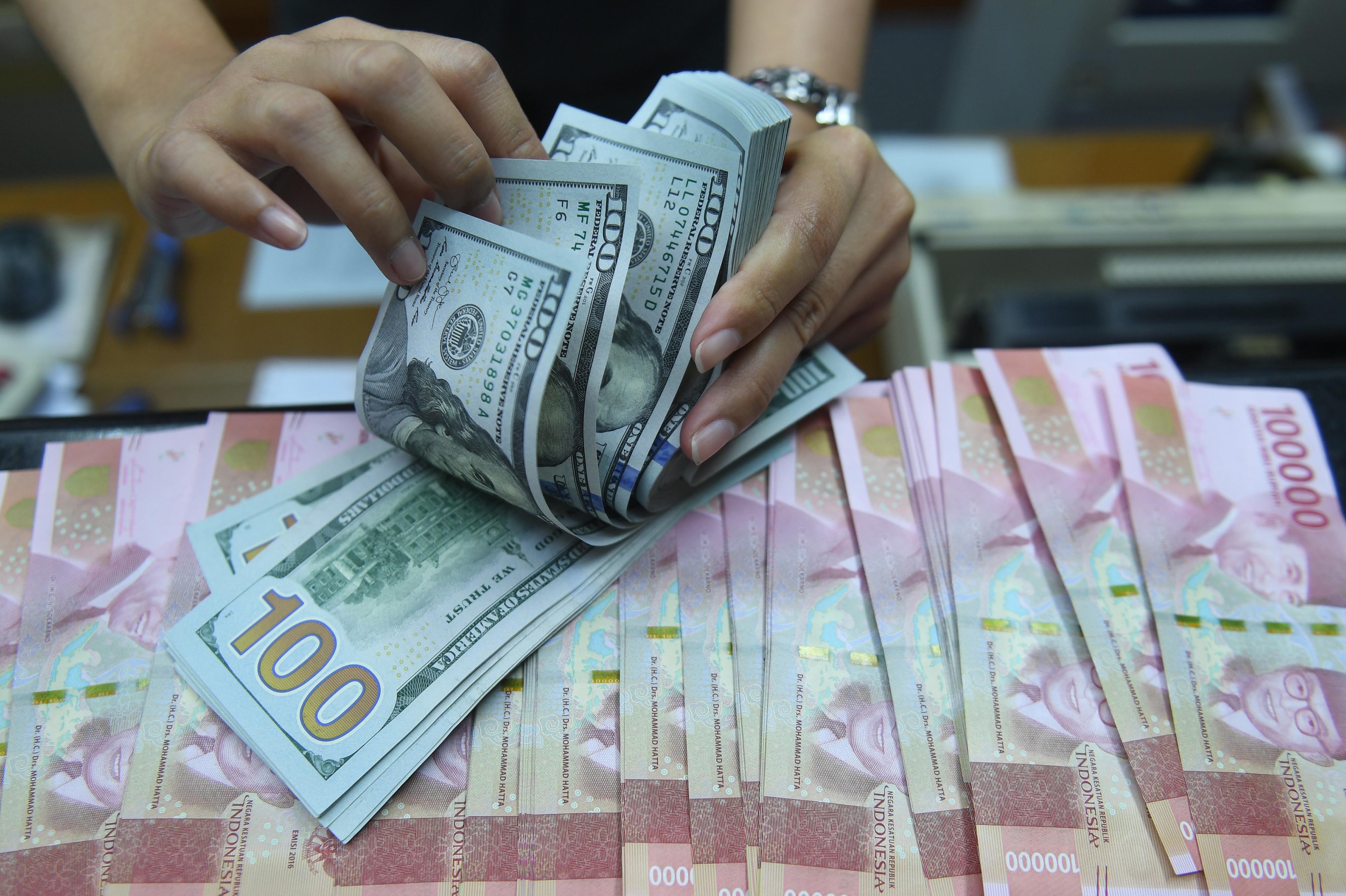  Pekerja menghitung uang Dollar Amerika Serikat dan Rupiah di sebuah tempat penukaran uang