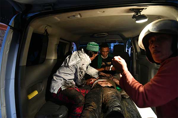 Seorang warga yang terluka mendapatkan perawatan saat bentrok antara polisi dan massa di Jalan KS Tubun, Jakarta, Rabu (22/5/2019)