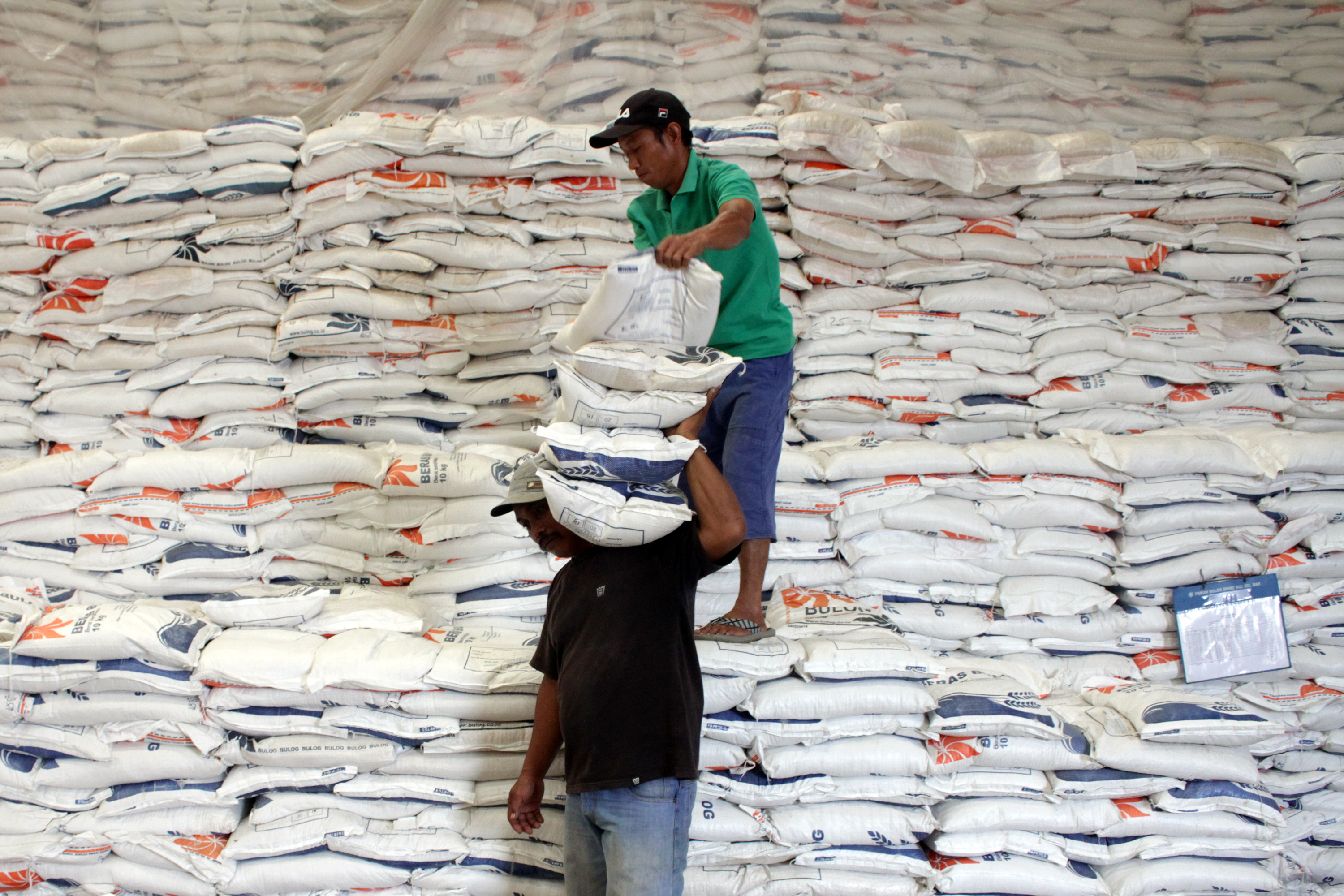Pekerja mengangkut beras di Gudang Beras Bulog