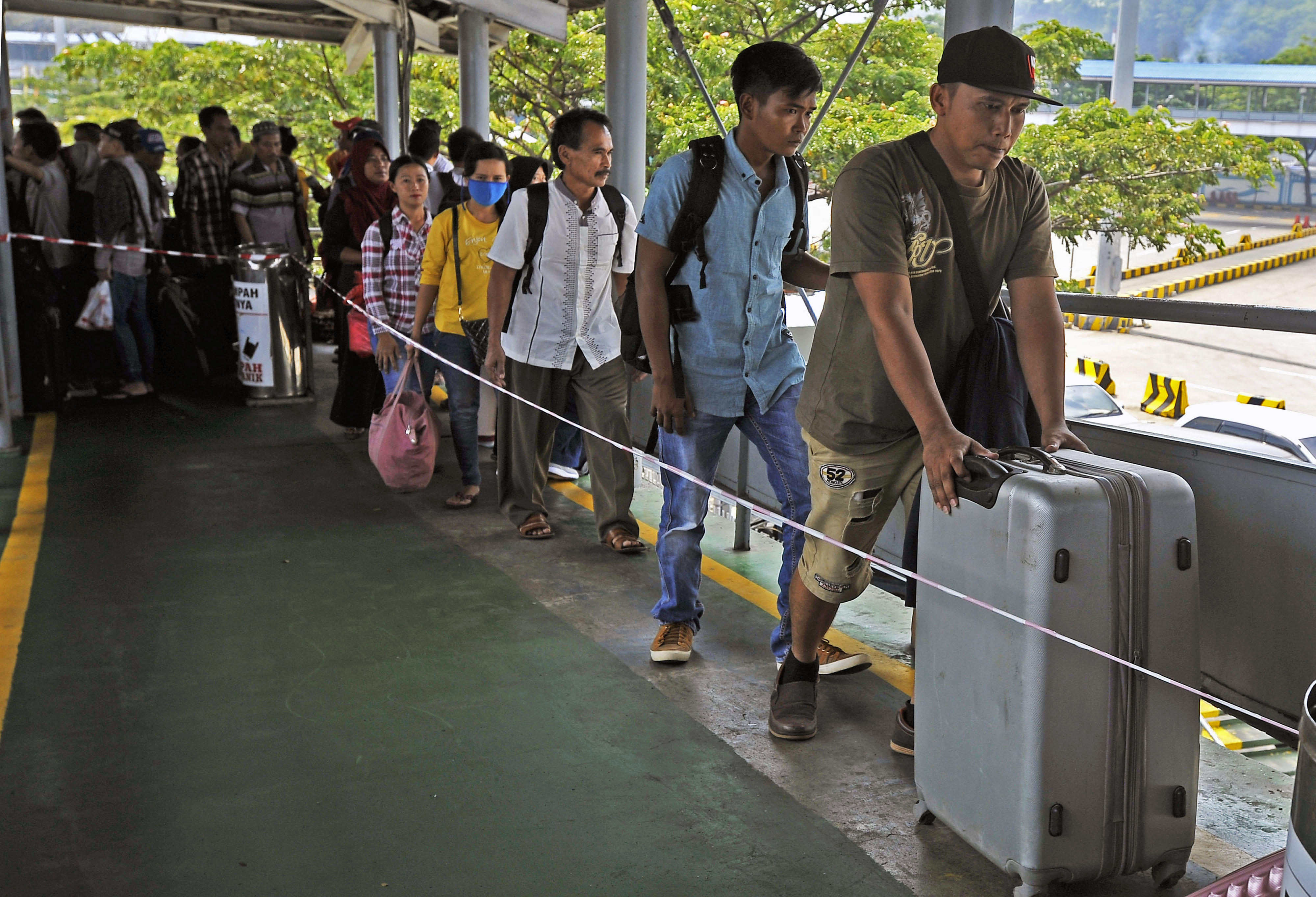 Sejumlah pemudik tujuan Sumatera yang pulang kampung lebih awal antre masuk kapal ferry di Pelabuhan Merak