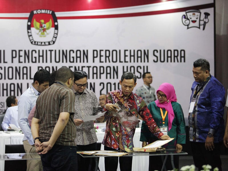 Komisioner KPU Pramono Ubaid Tanthowi memeriksa dokumen bersama berbagai pihak 