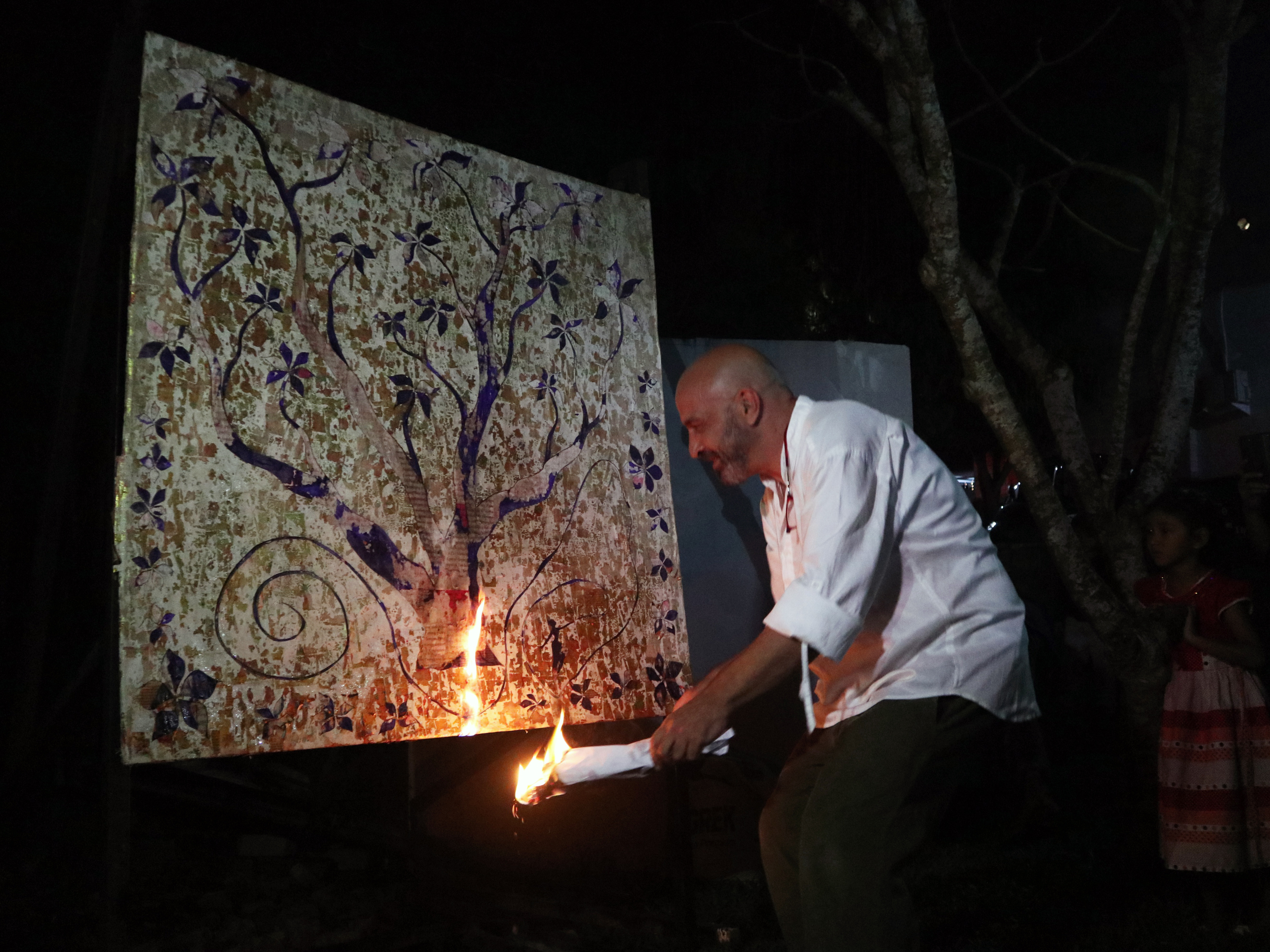 Perupa Rob Pearce membakar karyanya yang berjudul Pohon yang Jatuh dari Pohon.