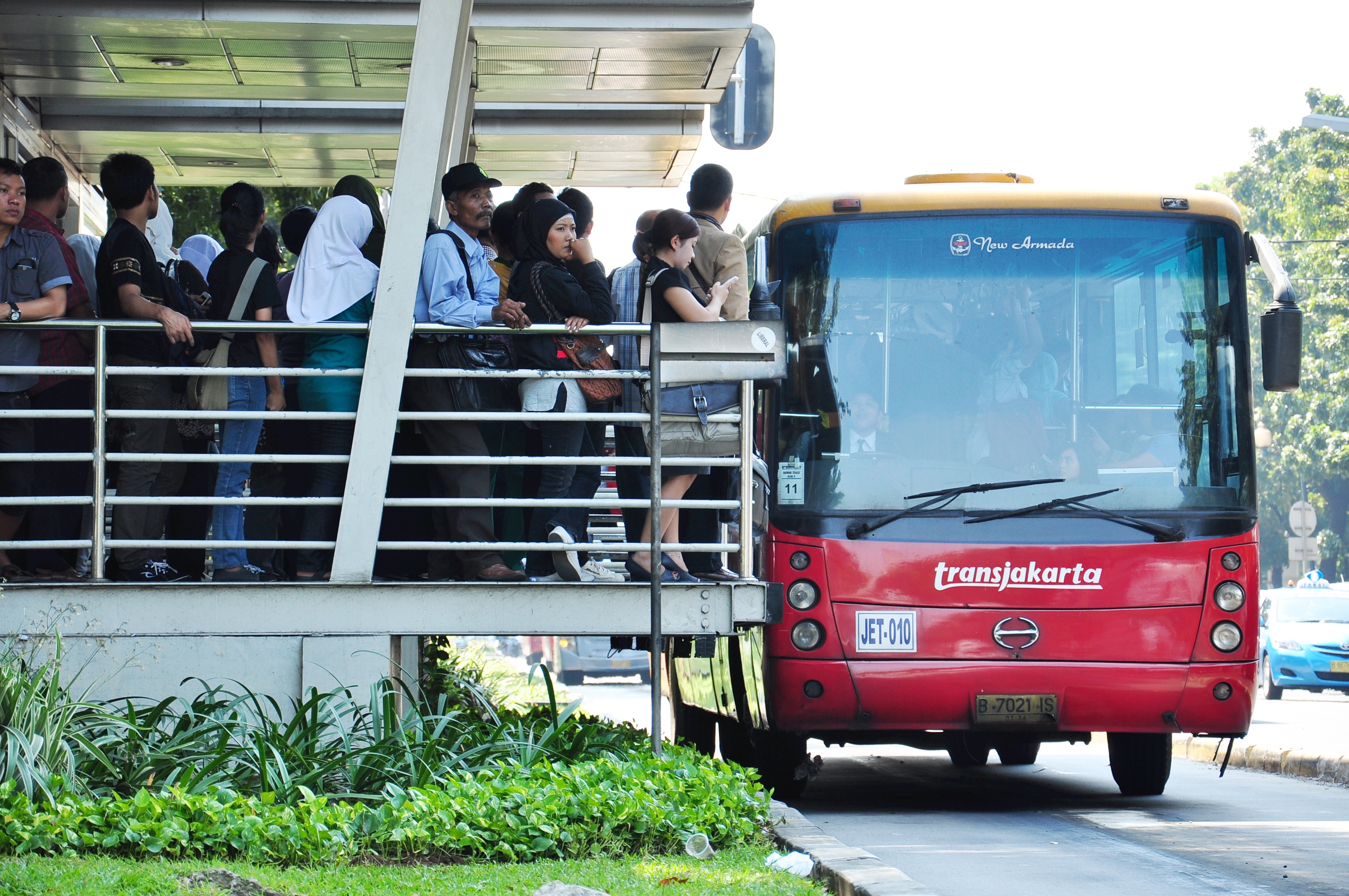 Sejumlah penumpang transjakarta mengantre di terminal Monumen Nasional di Jalan Merdeka Selatan, Jakarta.