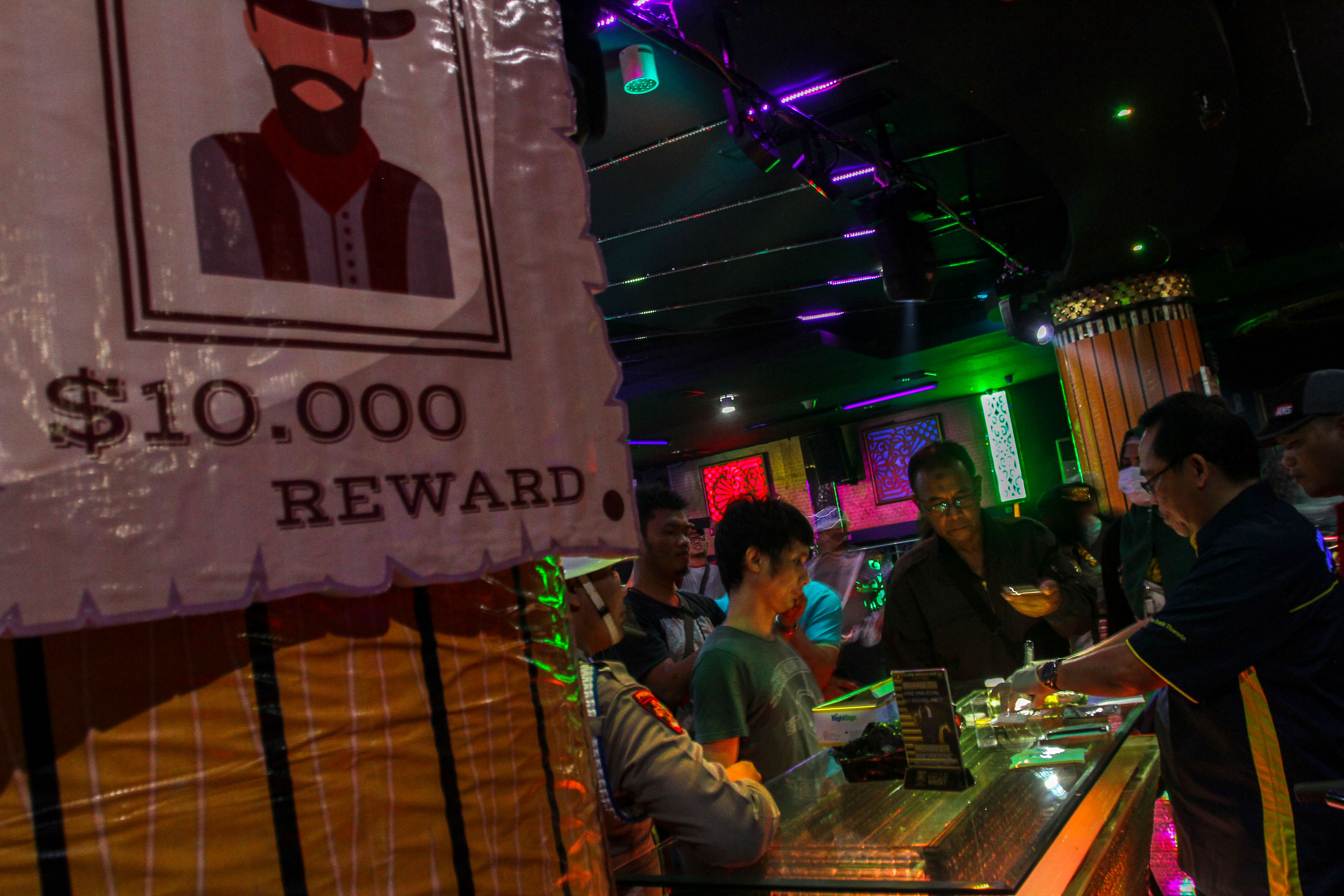 Personel Kepolisian Direktorat Reserse Narkoba Polda Riau mengetes sampel urine pengunjung di sebuah tempat hiburan malam. 