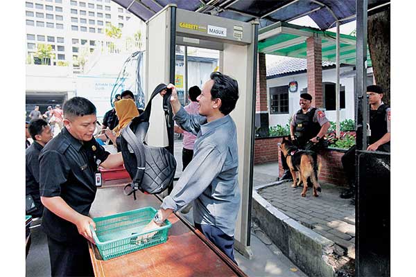 Petugas memeriksa pengunjung yang akan memasuki Gedung KPU, Jakarta, Rabu (15/5).