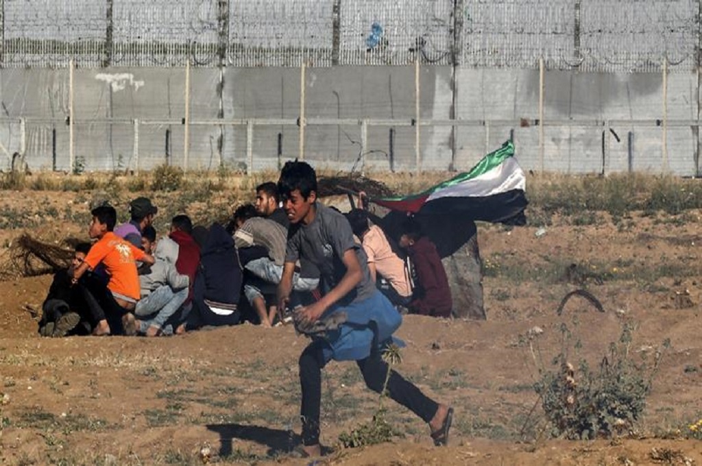 Demonstran muda berlari di sekitar pagar perbatasan Gaza dan Israel pada Jumat 10 Mei 2019. 