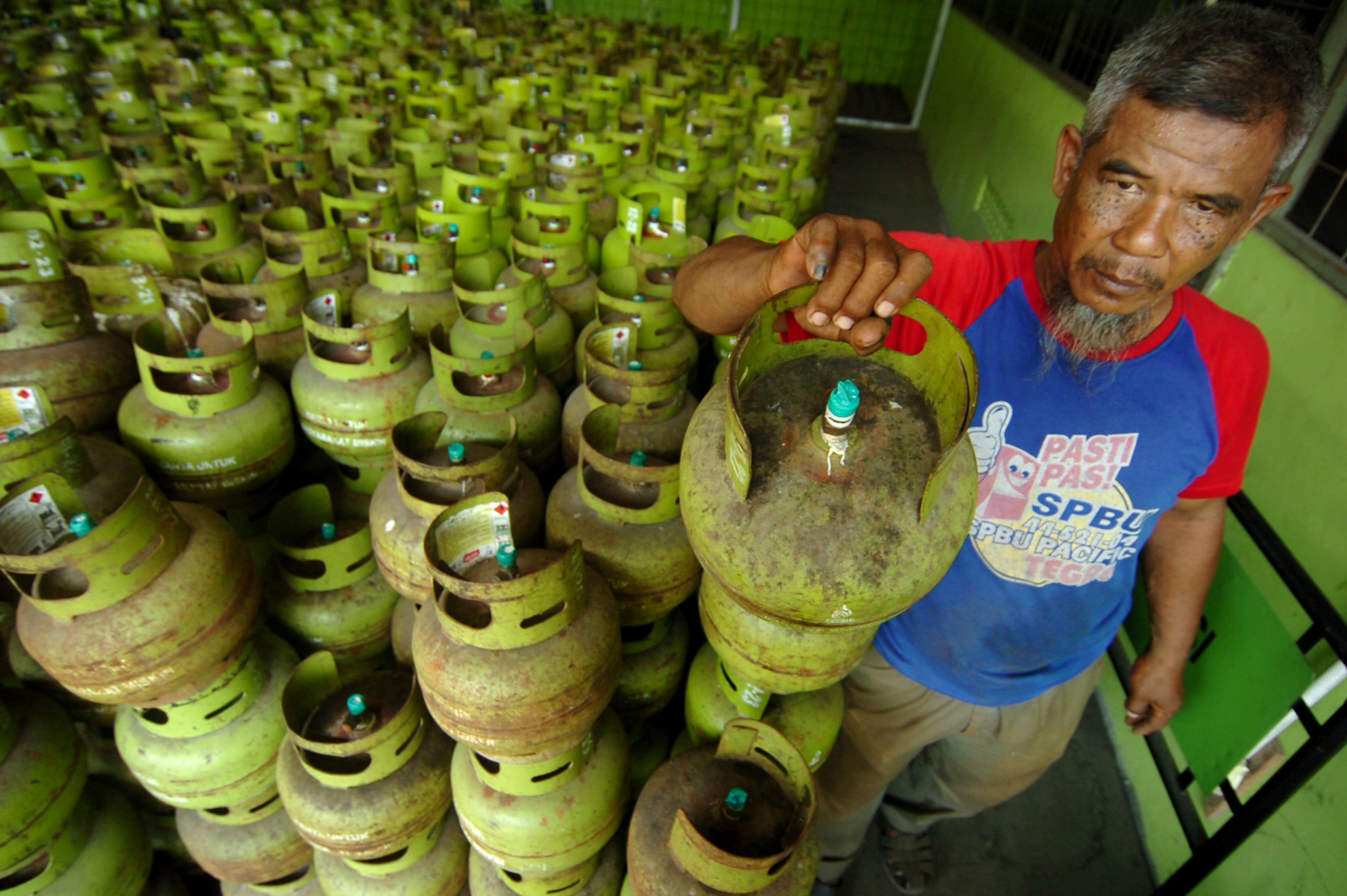 Pekerja mengangkat elpiji tiga kilogram di Pangkalan elpiji SPBU Muri, Kabupaten Tegal, Jawa Tengah, Senin (6/5/2019)