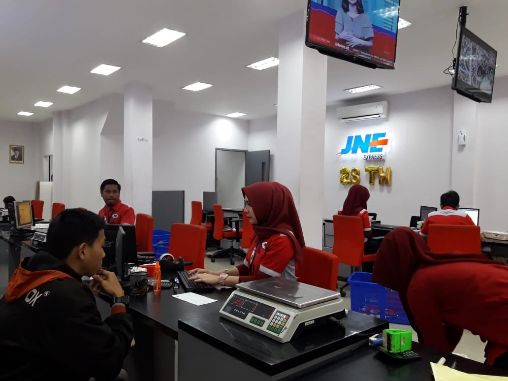  Pekerja melayani pelanggan jasa pengiriman di JNE Express