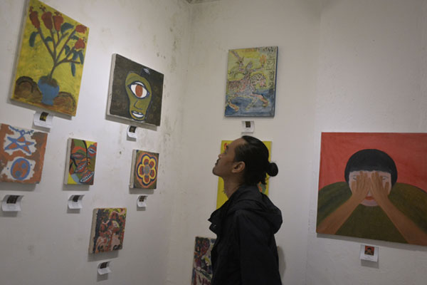 Pengunjung mengamati karya Orang Dengan Skizofrenia (ODS) yang dipamerkan di Rumah Berdaya, Denpasar, Bali, 