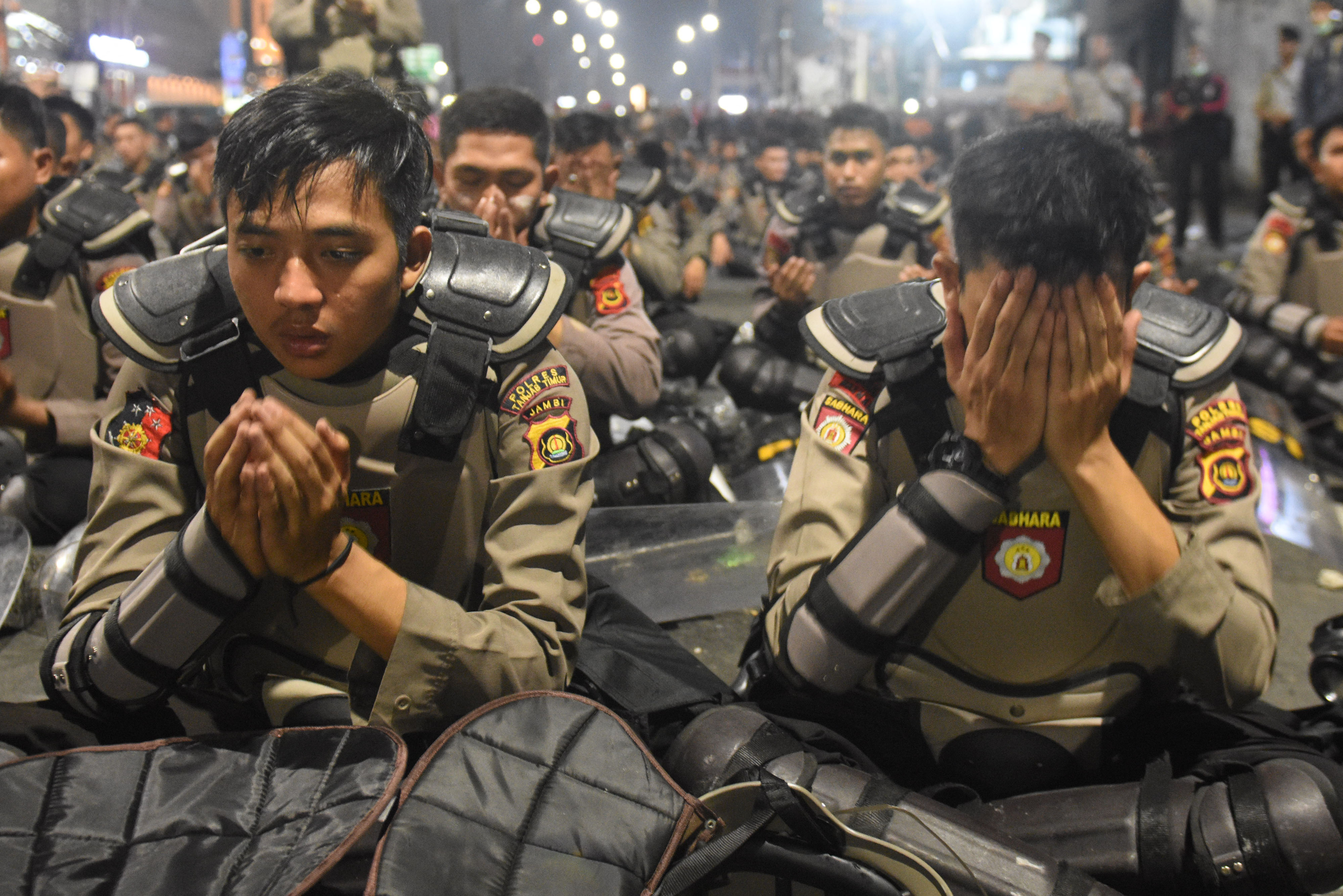 Sejumlah polisi berdoa bersama ketika tokoh masyarakat setempat menemui mereka di sela-sela terjadinya kericuhan dalam Aksi 22 Mei 