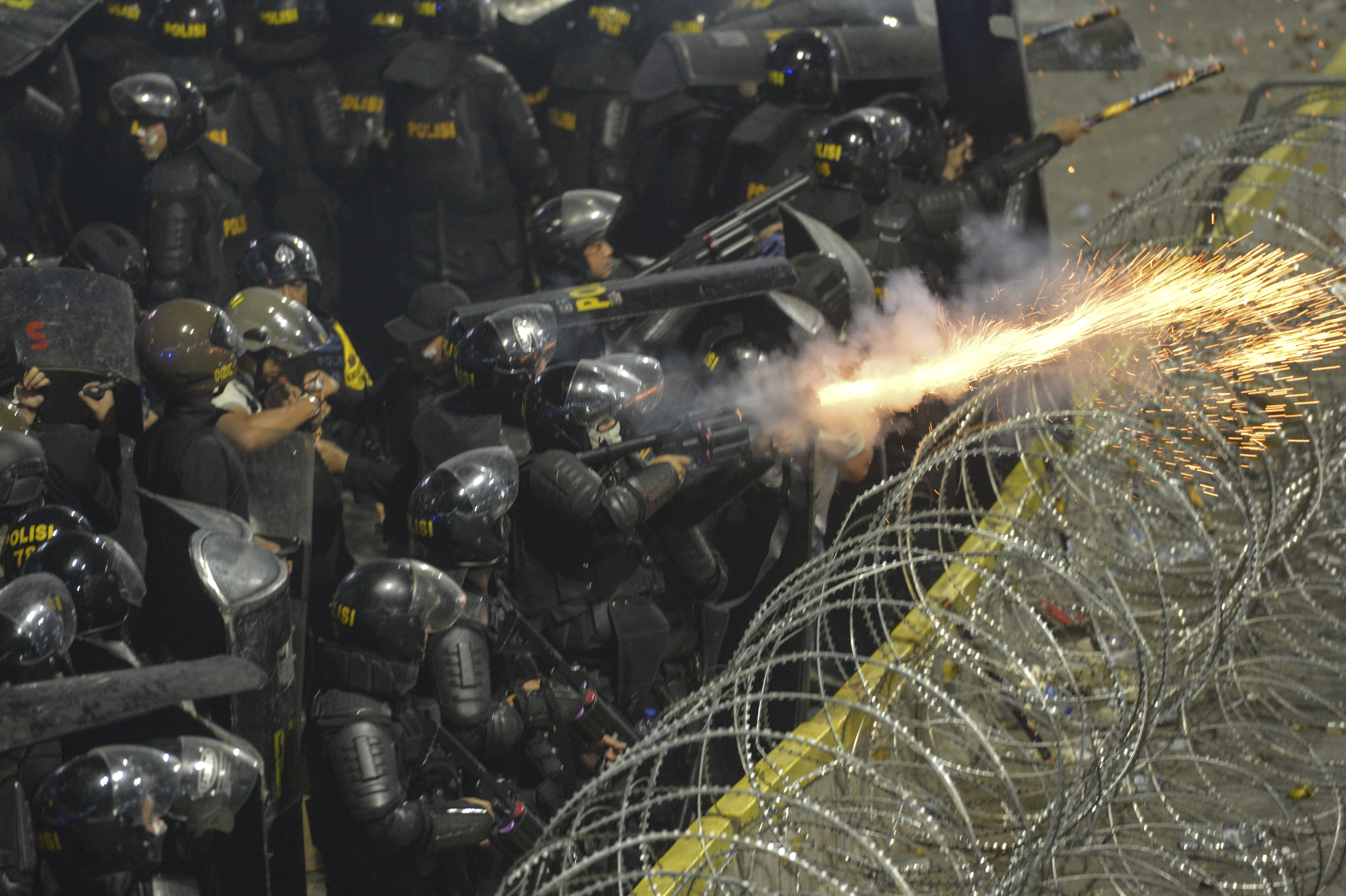 Personel kepolisian menembakkan gas air mata ketika terjadi kericuhan di depan gedung Bawaslu, Jakarta, Rabu (22/5). 