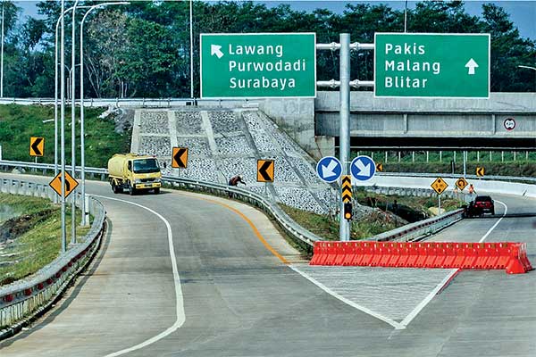 TOL PANDAAN-MALANG SIAP BEROPERASI: Pekerja menyelesaikan tahap akhir proyek pembangunan Tol Singosari di Malang, Jawa Timur, kemarin. Ruas 