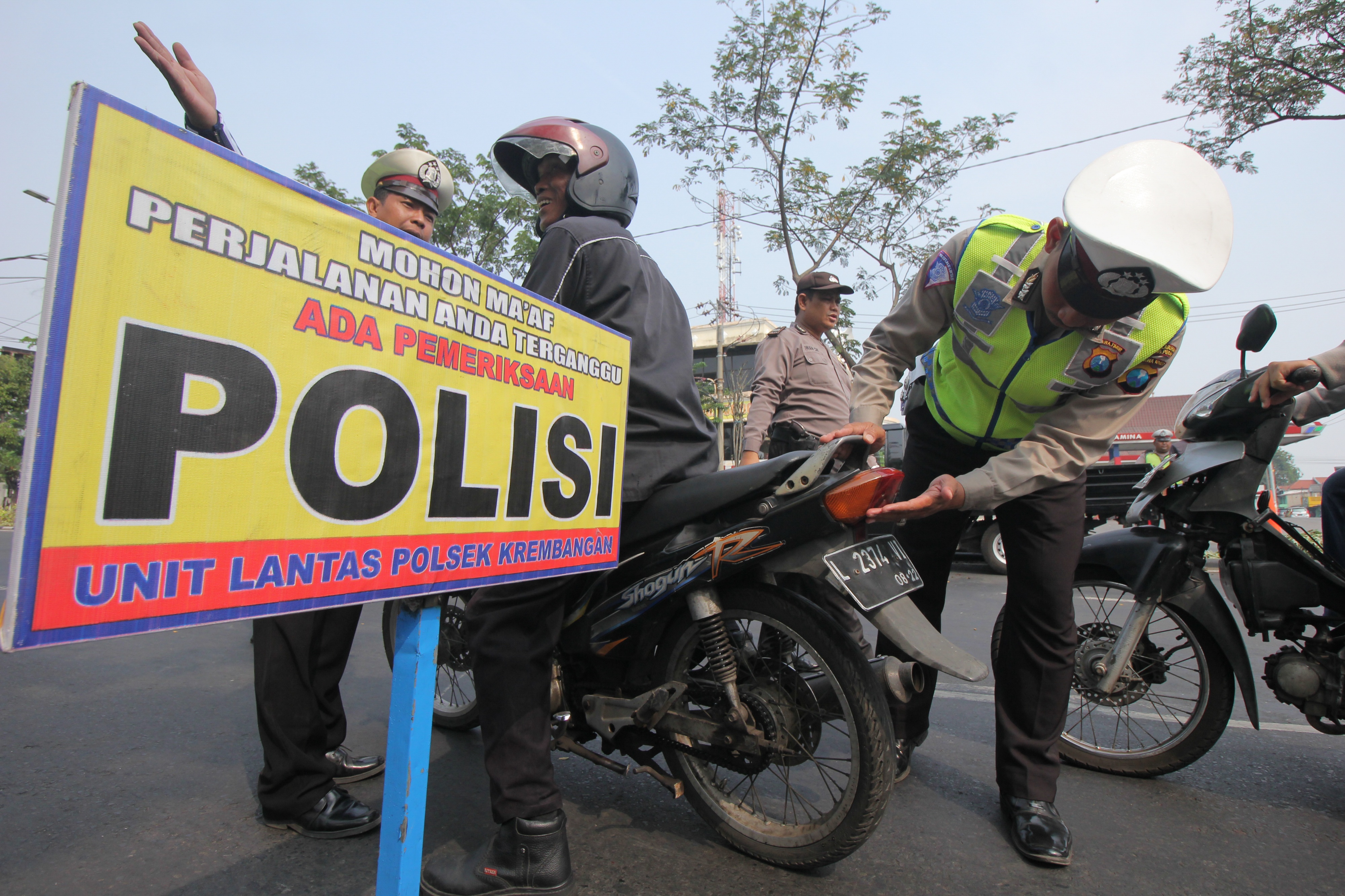 Polisi memeriksa lampu motor yang dikendarai warga saat Operasi Ketupat Semeru di Surabaya, Jawa Timur.