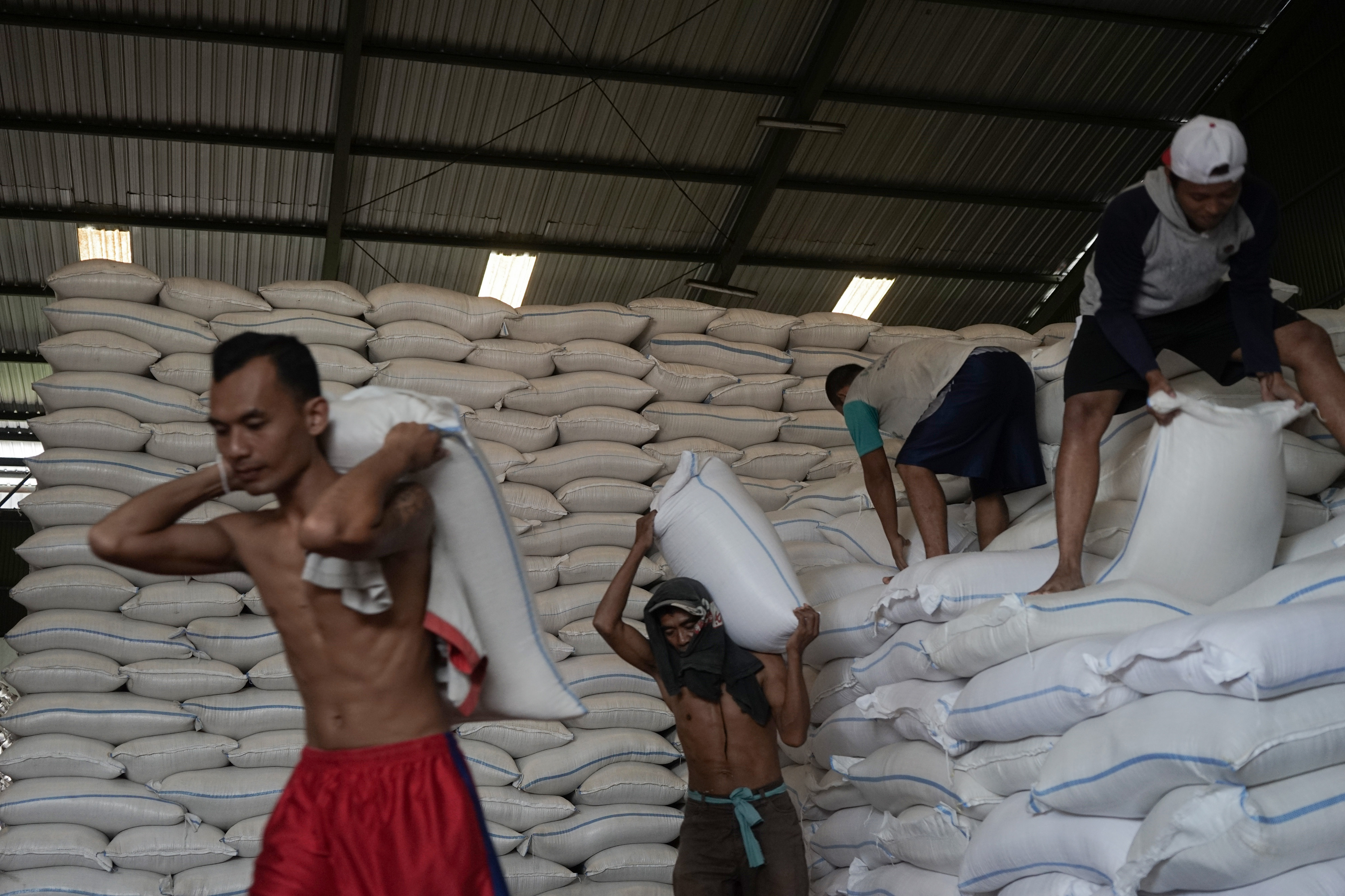  Pekerja mengangkut beras medium yang akan didistribusikan untuk operasi pasar,
