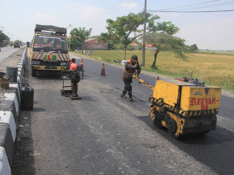Pekerja menyelesaikan perbaikan jalur pantura.