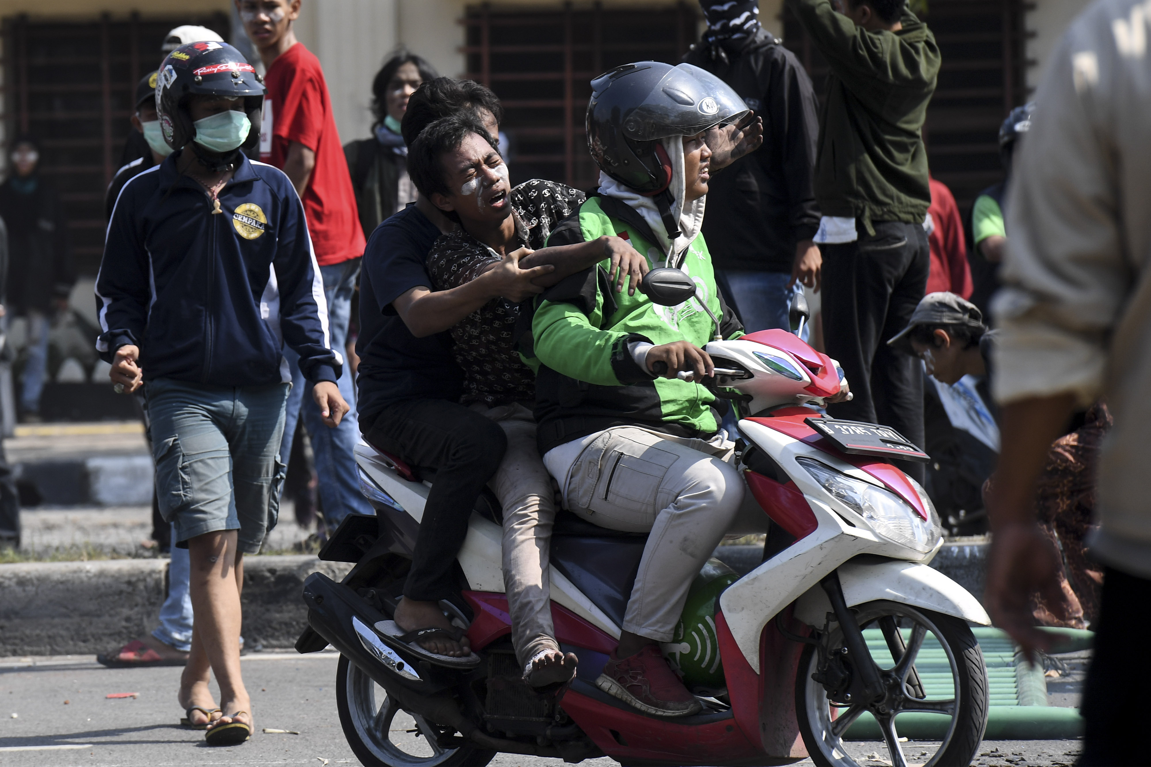 Warga yang terluka dievakuasi saat kerusuhan terjadi di Jalan Jati Baru Raya, Tanah Abang, Jakarta, Rabu (22/5)
