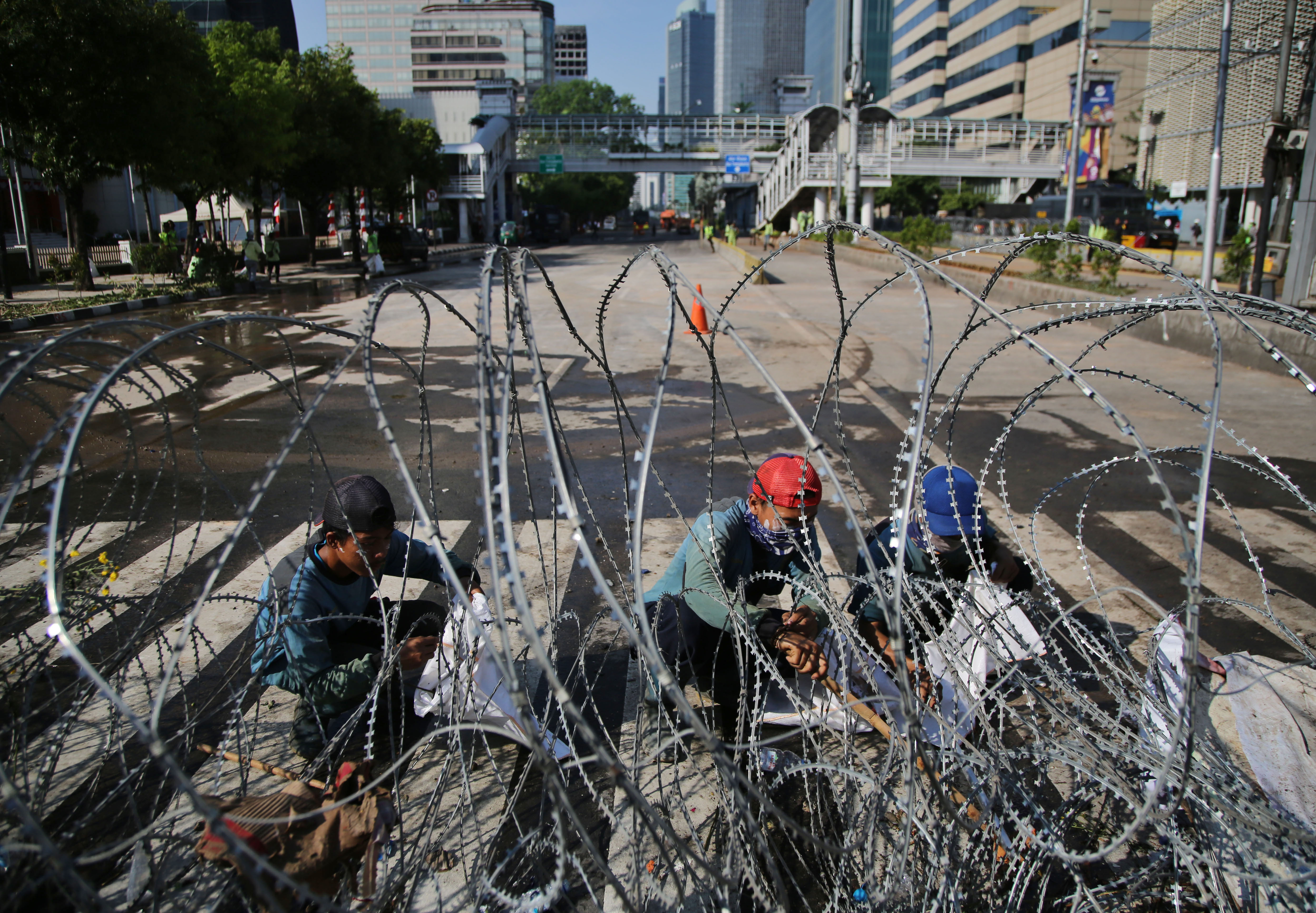  Petugas gabungan membersihkan sisa-sisa kerusuhan di depan Gedung Bawaslu, Jalan MH Thamrin, pascaaksi 22 Mei