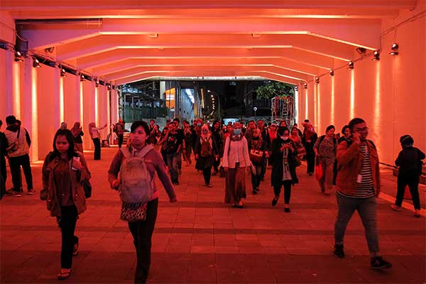 Warga berjalan melewati terowongan jalur pedestrian yang dihiasi lampu warna-warni di Jalan Kendal, dekat Stasiun Sudirman, kawasan Dukuh At