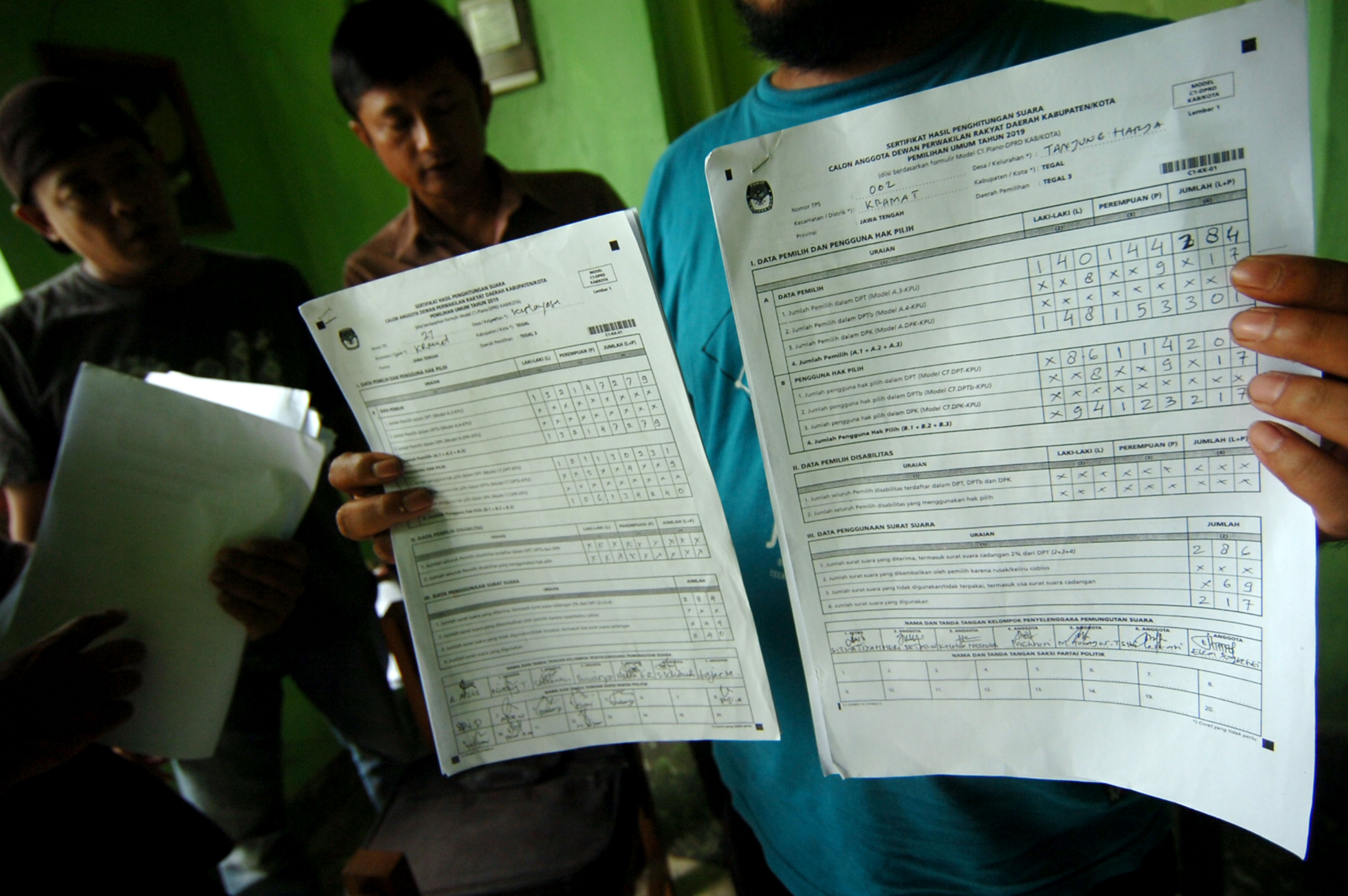 Seorang warga menunjukkan formulir C1.