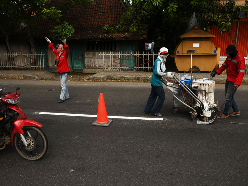 Pekerja mengecat marka jalan di jalan jalur Pantura Demak, Jawa Tengah.