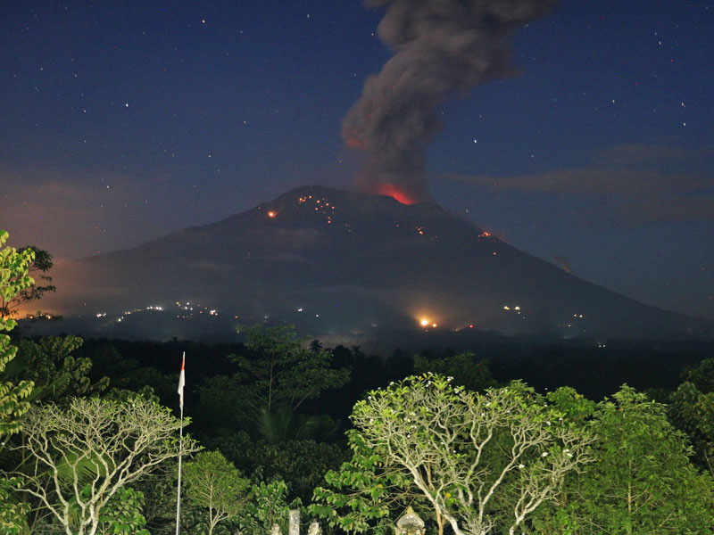 Abu vulkanis dan batu pijar terlontar dari kawah Gunung Agung.