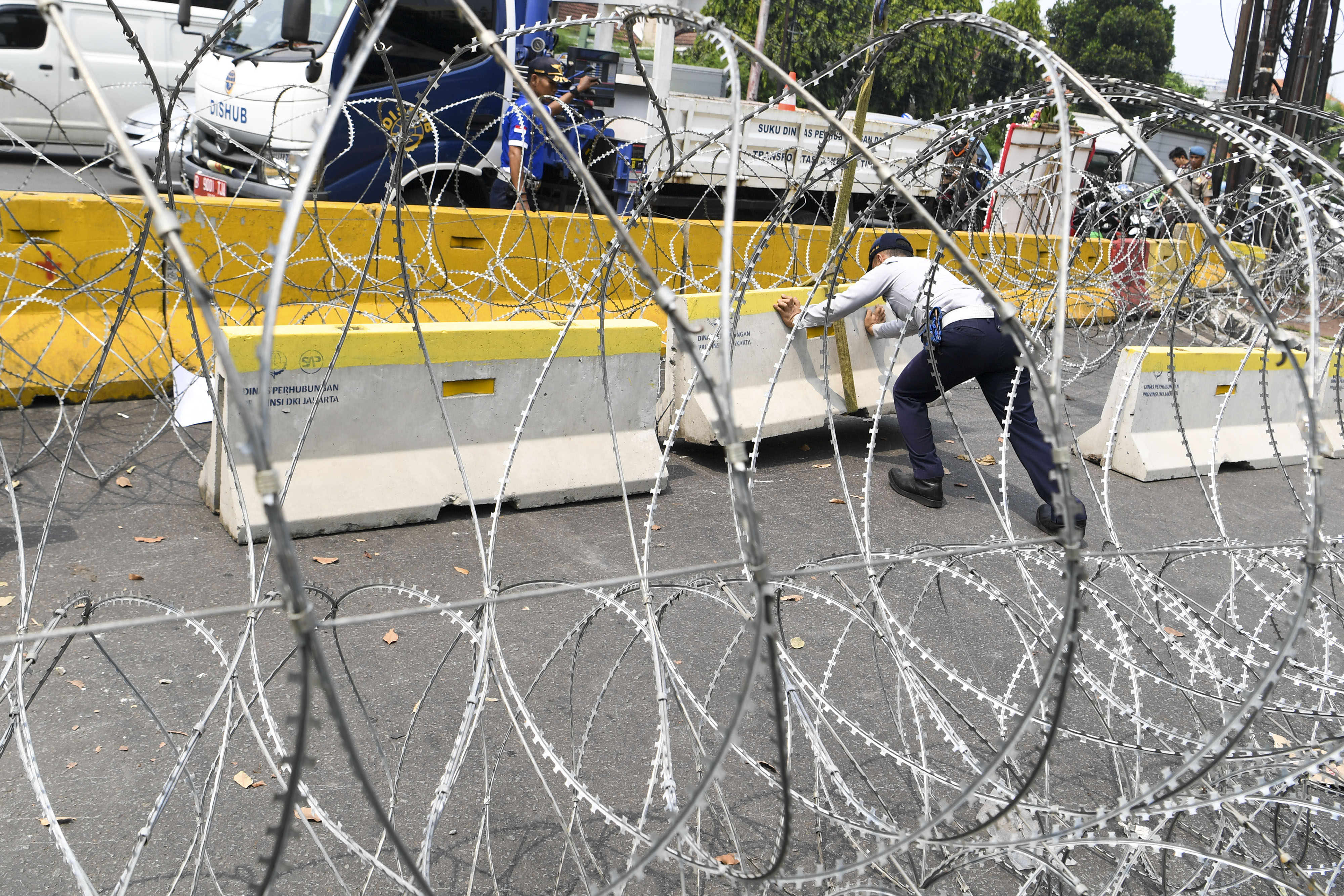 Petugas Dinas Perhubungan memasang beton penghalang di jalan menuju arah gedung KPU di Jalan Imam Bonjol, Jakarta.