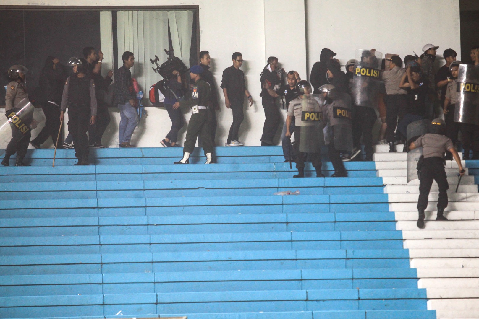 Polisi mengamankan penonton selepas bentrokan antarpendukung di laga antara PSS Sleman dan Arema FC