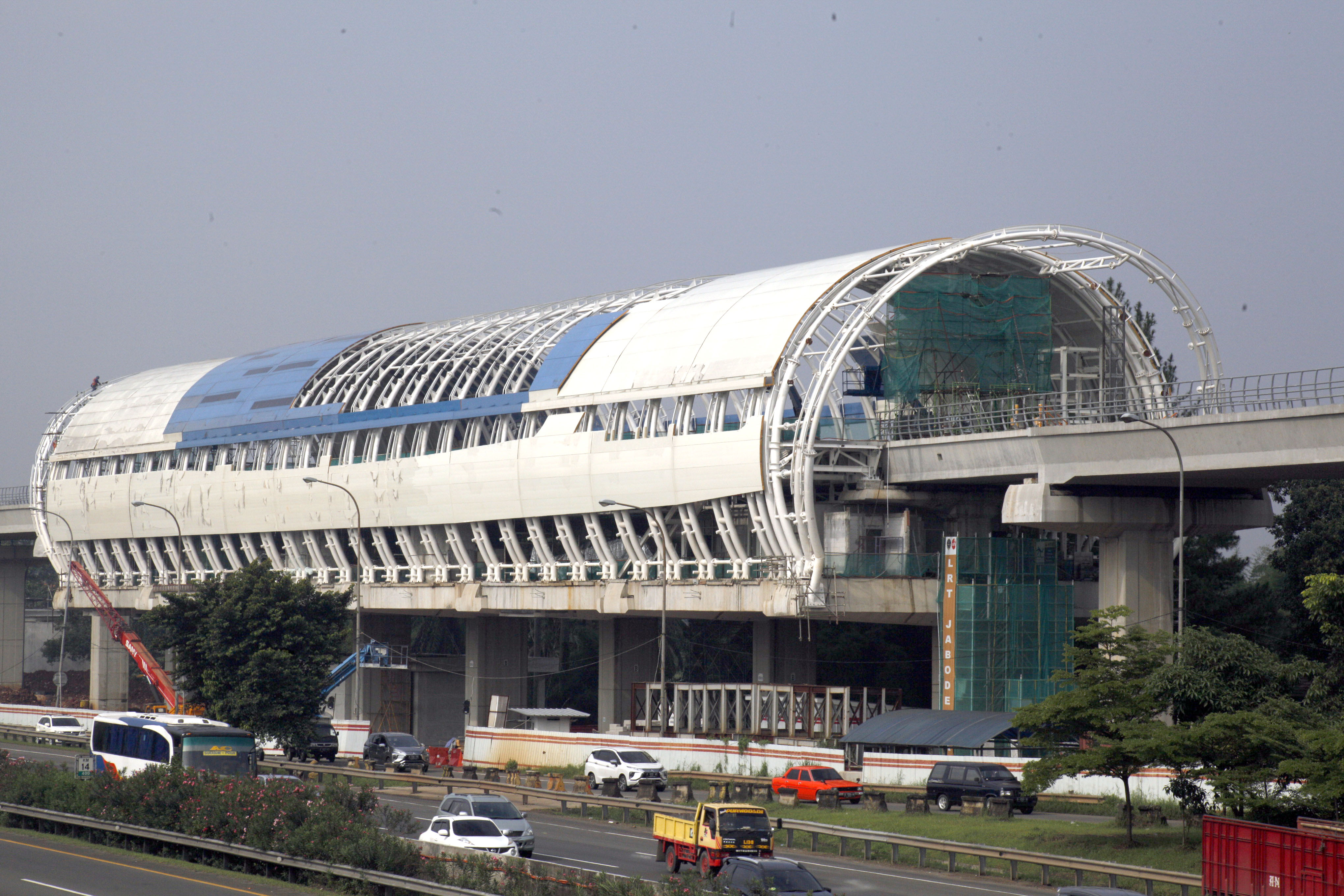 Sejumlah pengendara kendaraan melintas di dekat area proyek pembangunan infrastruktur LRT di ruas Jalan Tol Jagorawi, Cibubur, Jakarta Timur