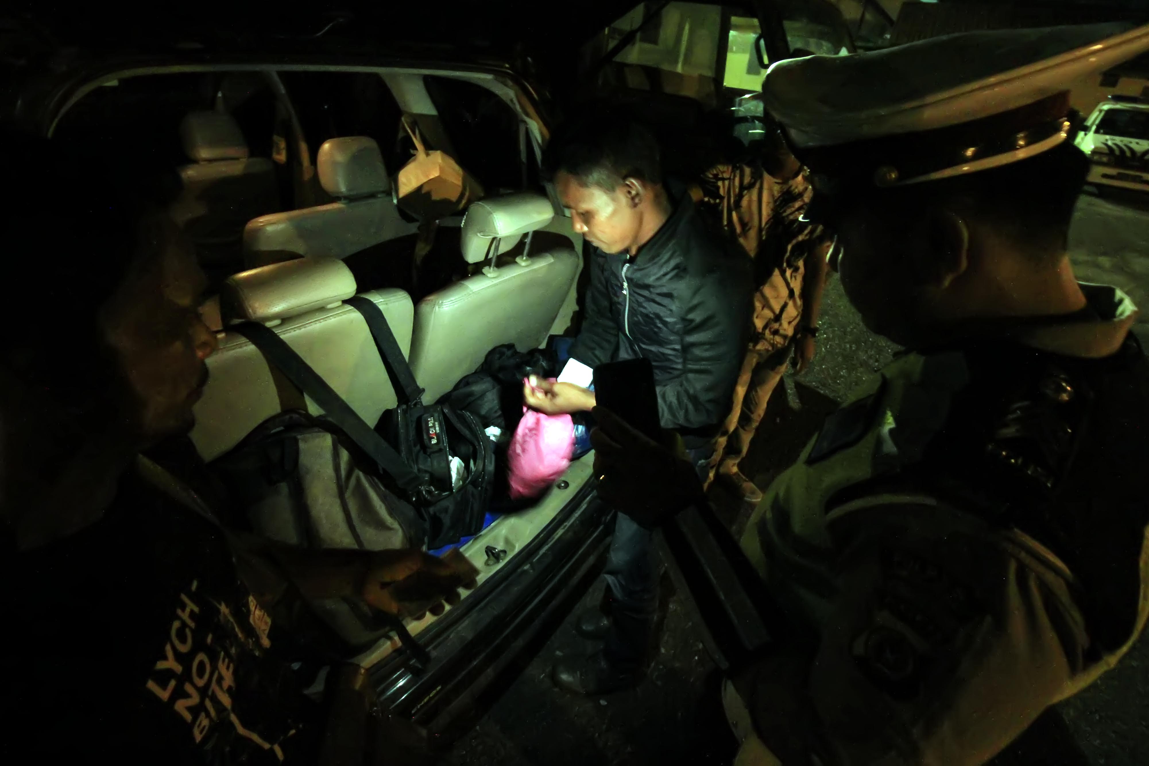 Polisi memeriksa Kartu Tanda Penduduk (KTP) dan barang bawaan para penumpang angkutan umum saat berlangsung razia