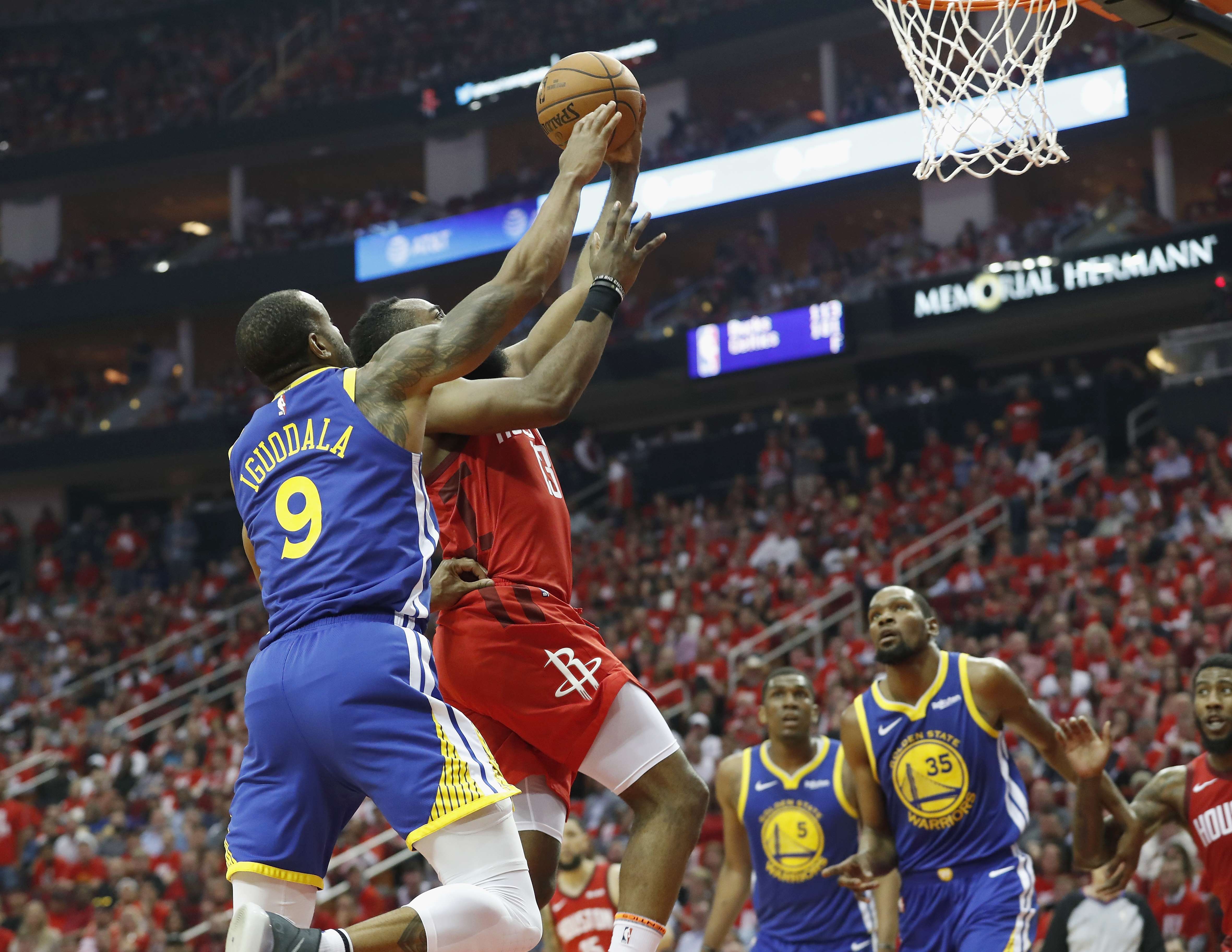 James Harden # 13 dari Houston Rockets maju untuk melakukan tembakan yang dibela oleh Andre Iguodala # 9 dari Golden State Warriors 