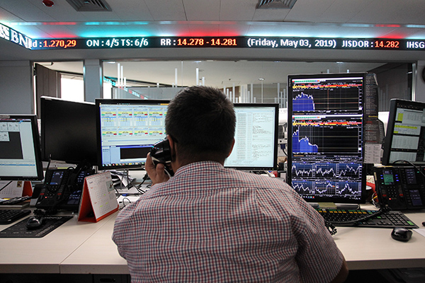 Pialang mengamati layar pergerakan saham 