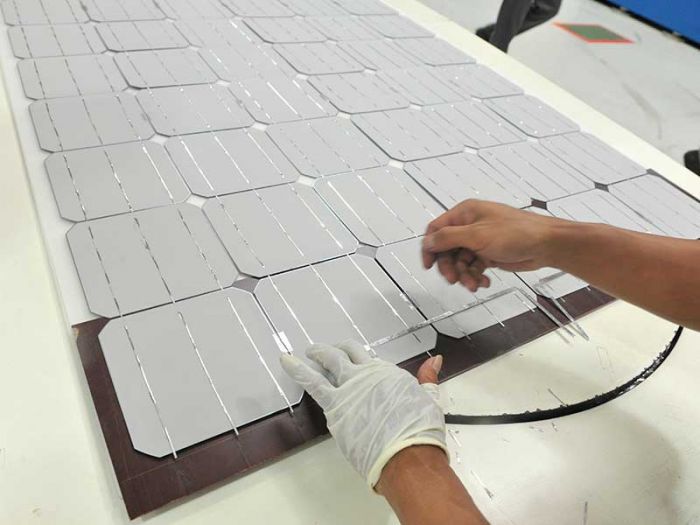  Pekerja menyelesaikan pembuatan rangkaian sel surya (solar cell)