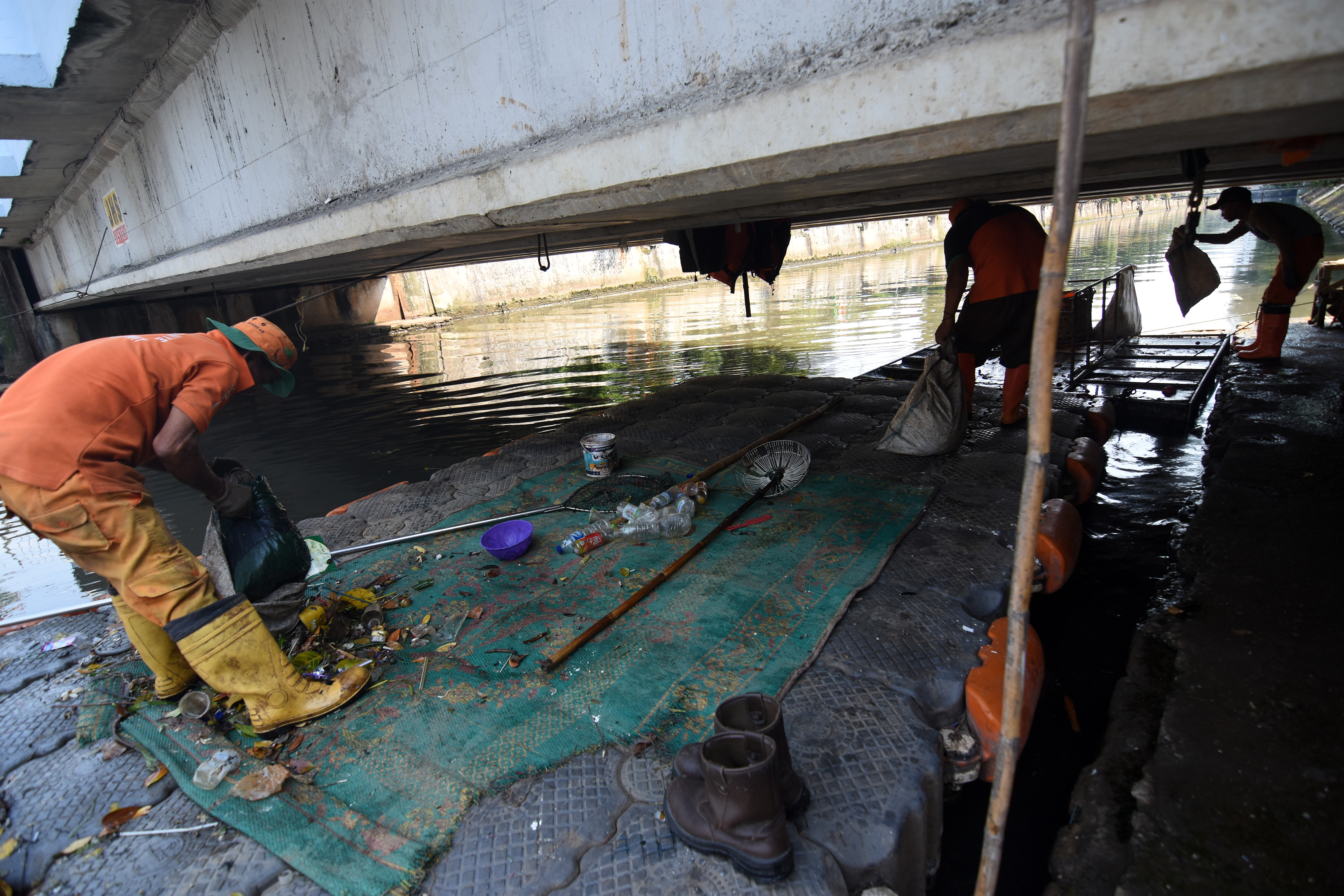 Petugas UPK Badan Air Dinas Lingkungan Hidup DKI Jakarta membersihkan sampah sebagai bagian dari naturalisasi di aliran air Kali Ciliwung.