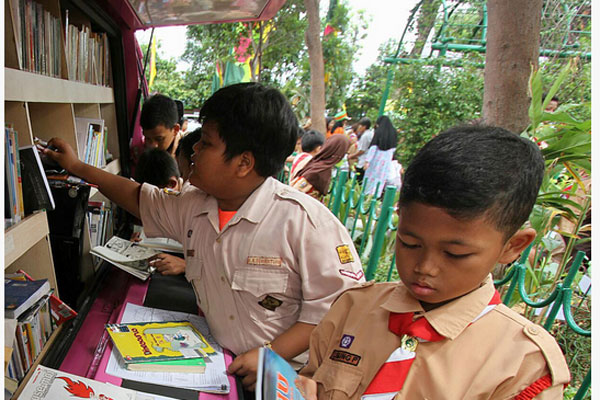  Sejumlah anak-anak membaca buku perpustakaan keliling di Ruang Publik Terpadu Ramah Anak (RPTRA) 