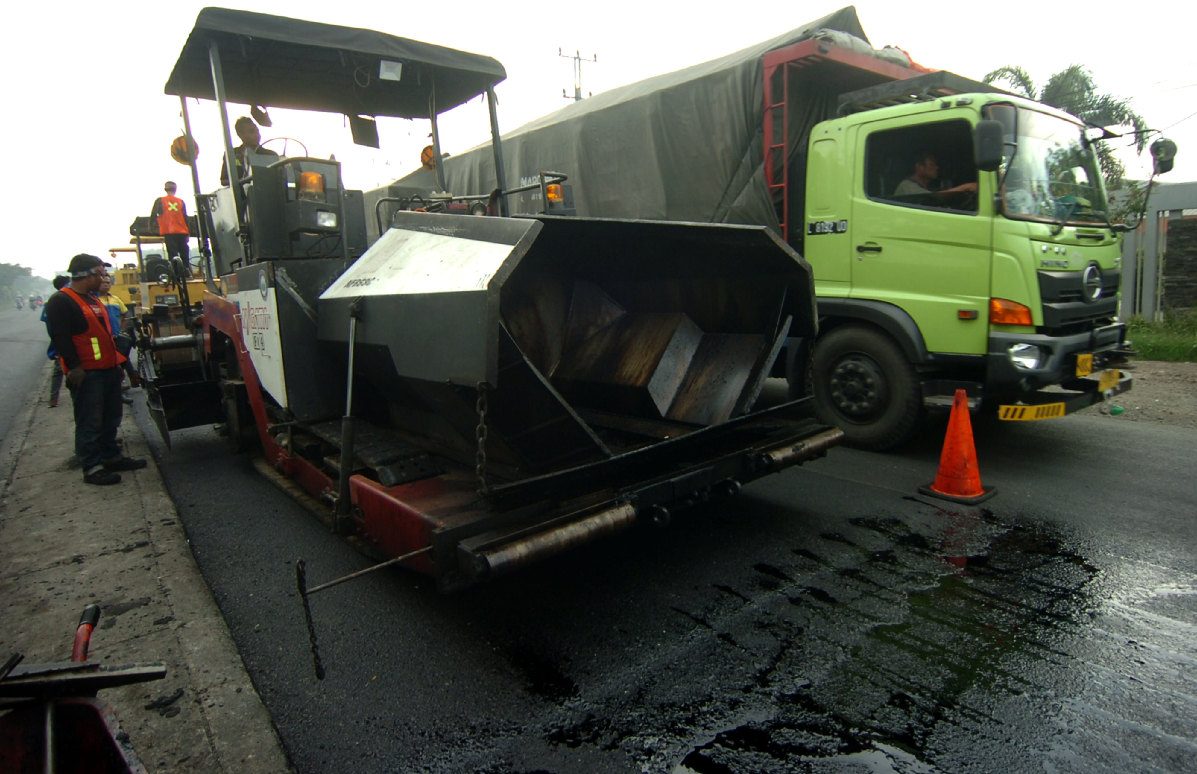 Sejumlah pekerja melakukan proses perbaikan jalan di jalur Pantura