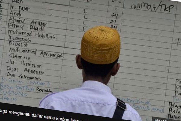 Seorang warga mengamati daftar nama korban luka kericuhan di RSUD Tarakan, Jakarta Pusat, Rabu (22/05) 