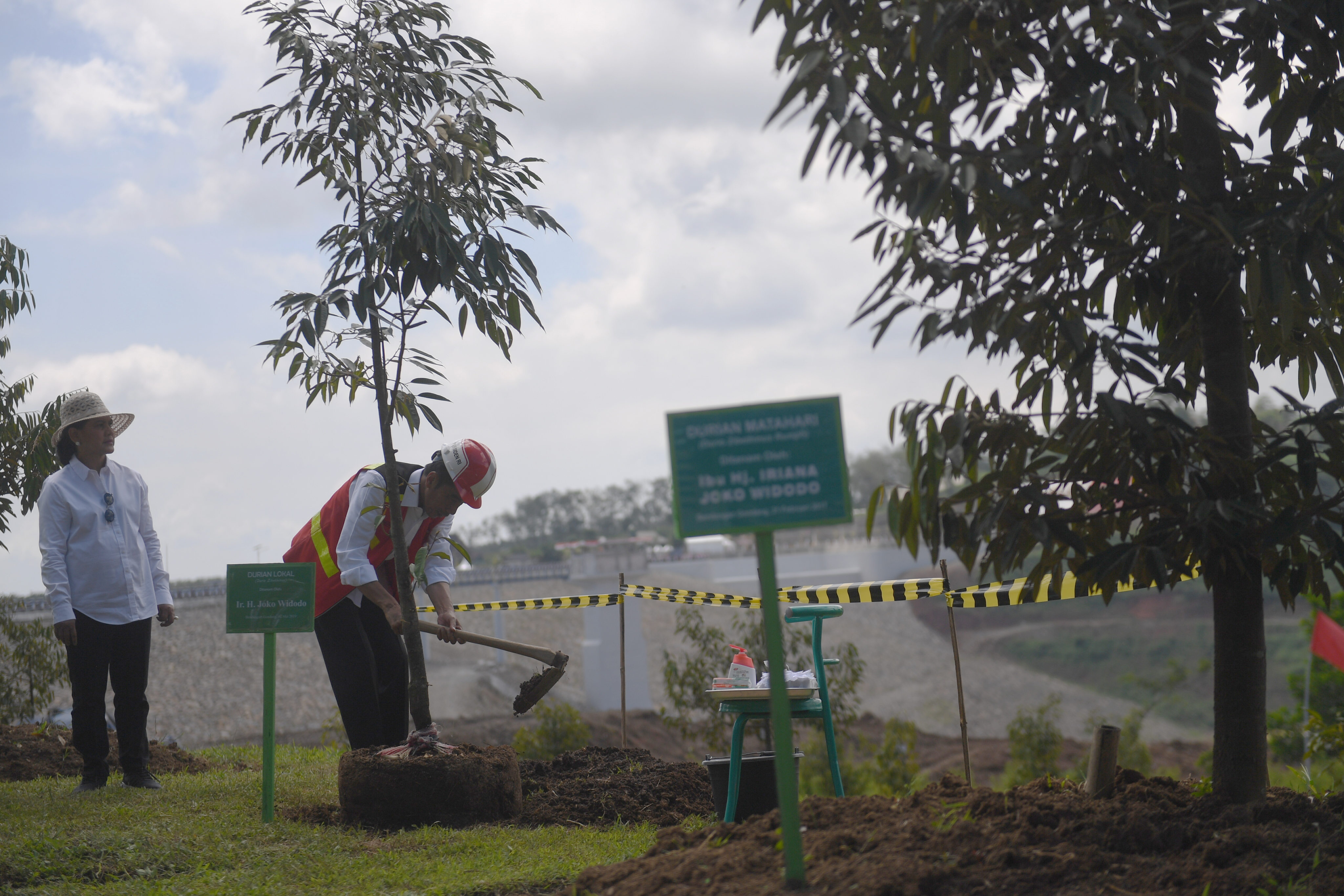 Presiden Joko Widodo (kanan) didampingi Ibu Negara Iriana Joko Widodo (kiri) menanam pohon durian di tepian Bendungan Gondang, Karanganyar, 
