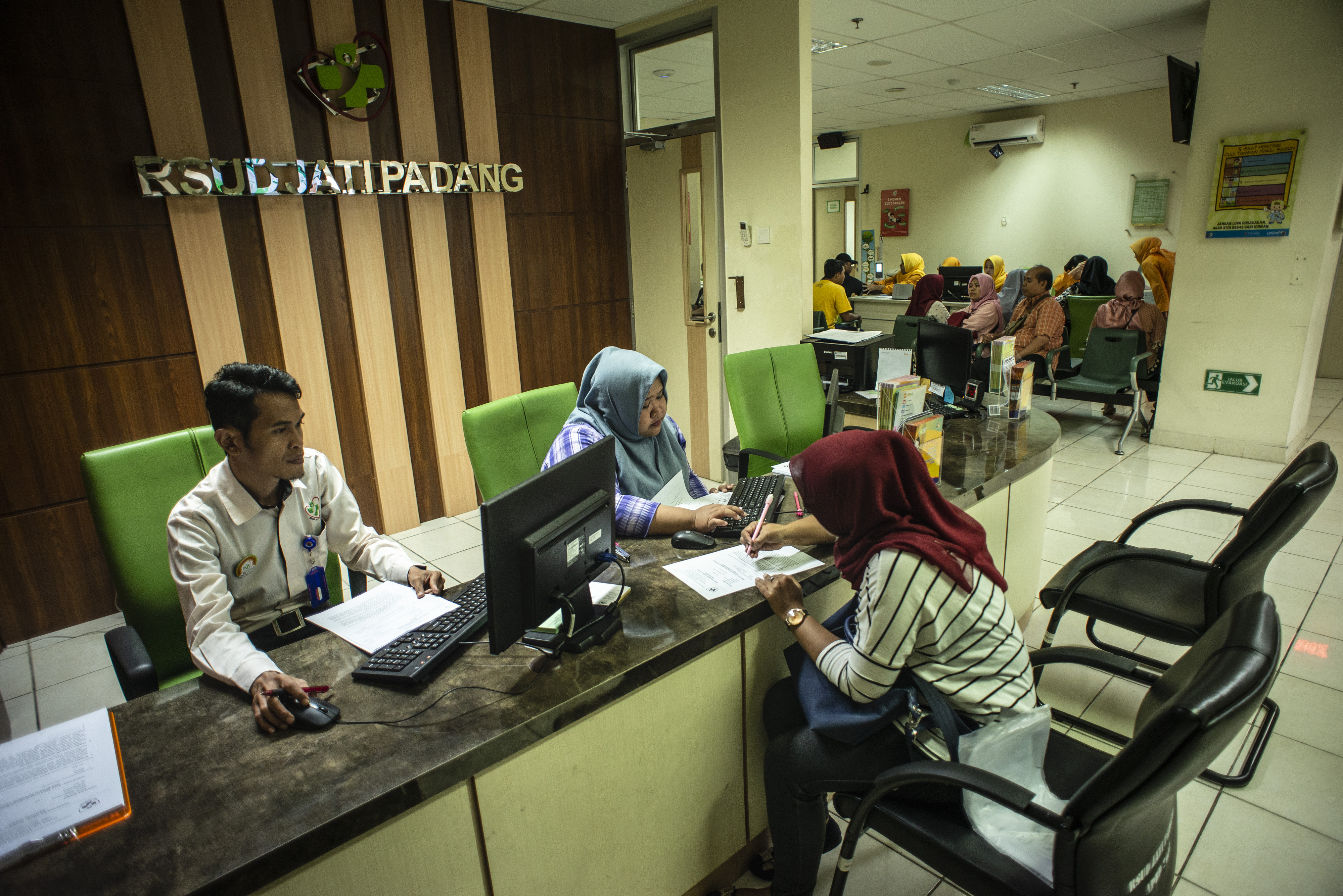  Petugas melayani calon pasien menyelesaikan proses administrasi di RSUD Jati Padang, Jakarta