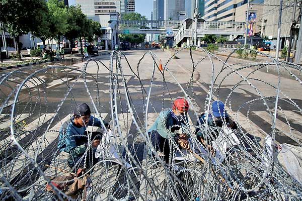 Petugas gabungan membersihkan sisa-sisa kerusuhan di depan Gedung Bawaslu, Jalan MH Thamrin, Jakarta, kemarin. Pascakerusuhan dalam aksi 22