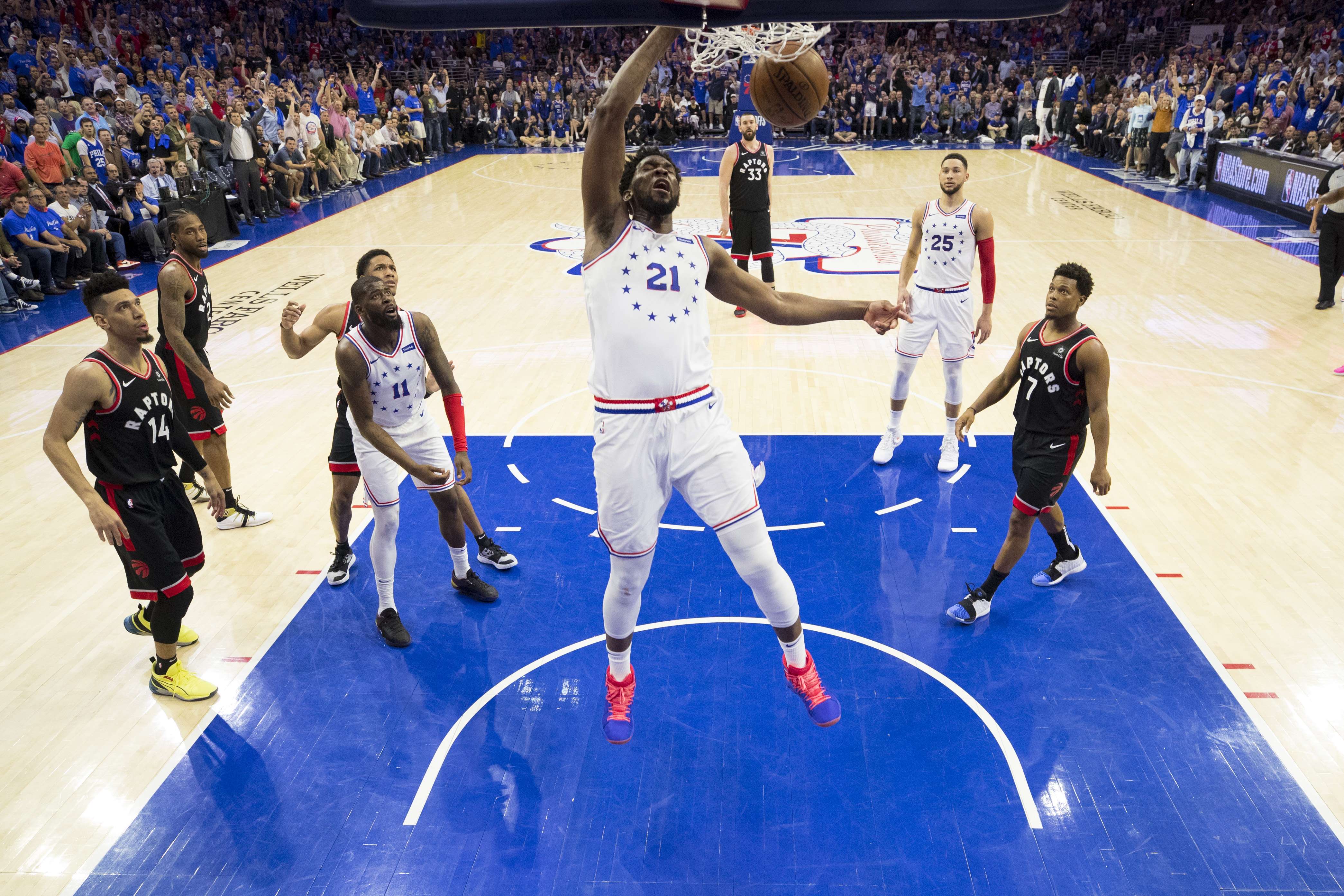 Joel Embiid No. 21 dari Philadelphia 76ers dunks bola melawan Toronto Raptors pada kuarter keempat 