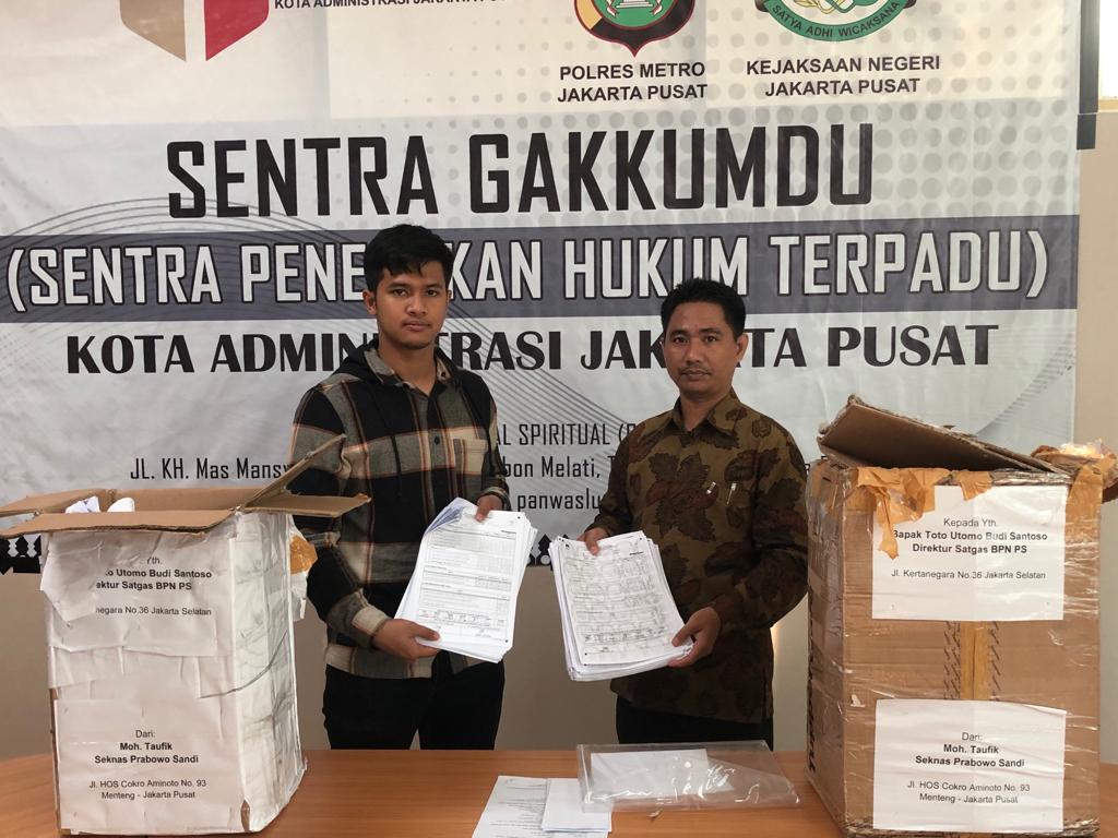 Dua petugas Bawaslu menunjukkan formulir C1 yang ditemukan polisi saat razia di kawasan Menteng.