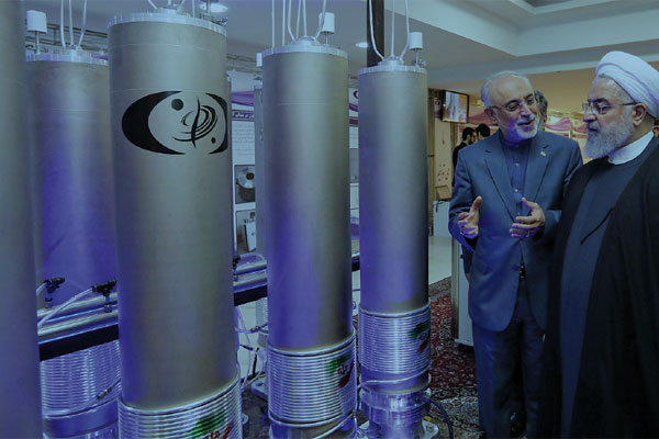 Presiden Iran Hassan Rouhani (kanan) mendengarkan penjelasan kepala organisasi teknologi nuklir Iran, Ali Akbar Salehi,